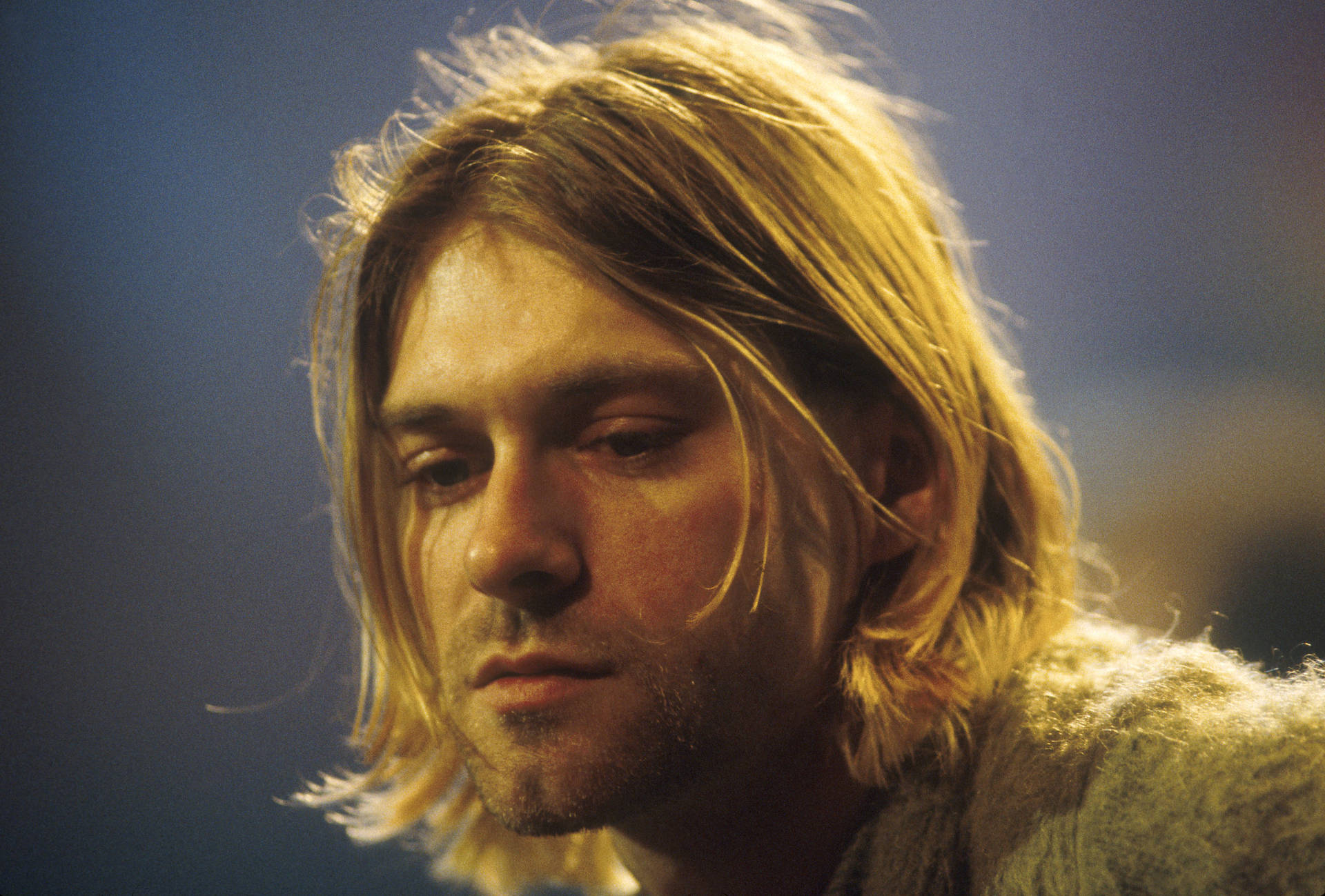 Kurt Cobain 喺近距離肖像中，頭髮亂糟糟，表情嚴肅。