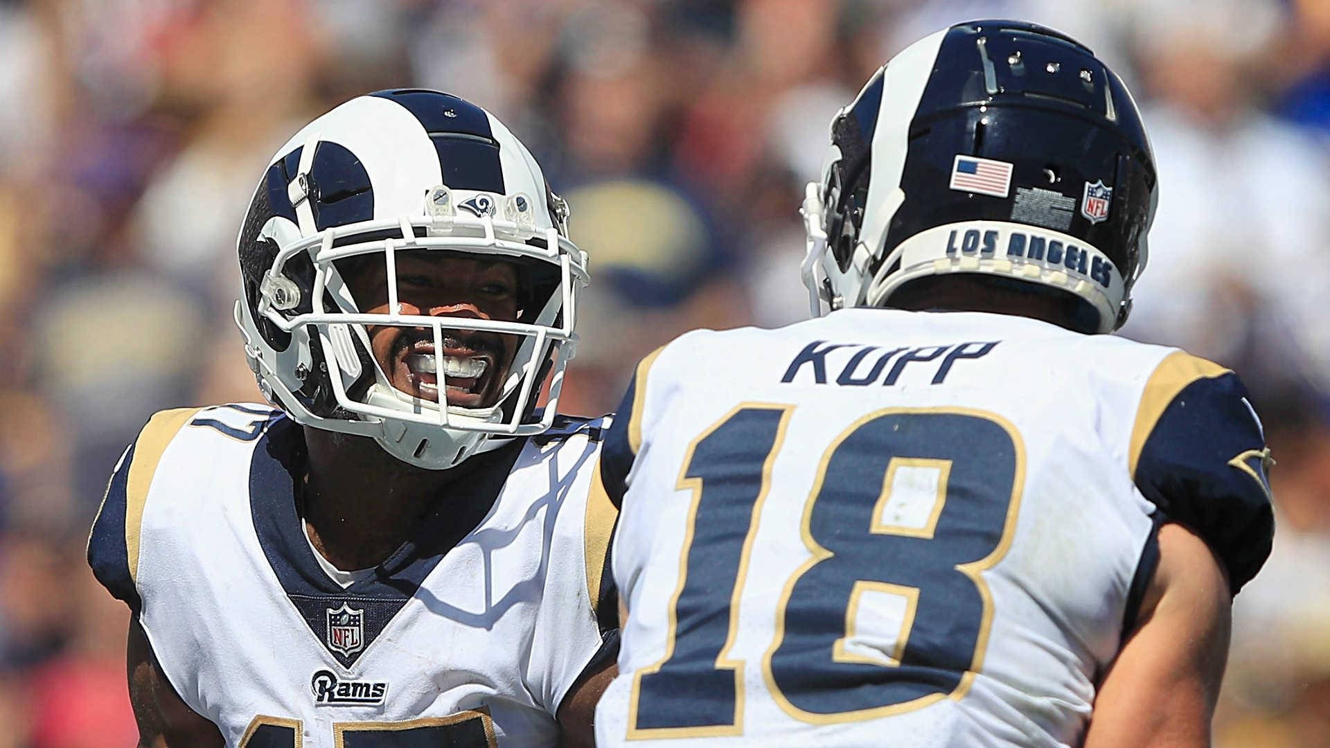 科珀·庫普 NFL 洛杉磯拉姆斯隊隊友攝影 壁紙 — 兩名洛杉磯公羊隊的足球員在陽光明媚的比賽日激烈慶祝，身後是模糊的體育場人群。