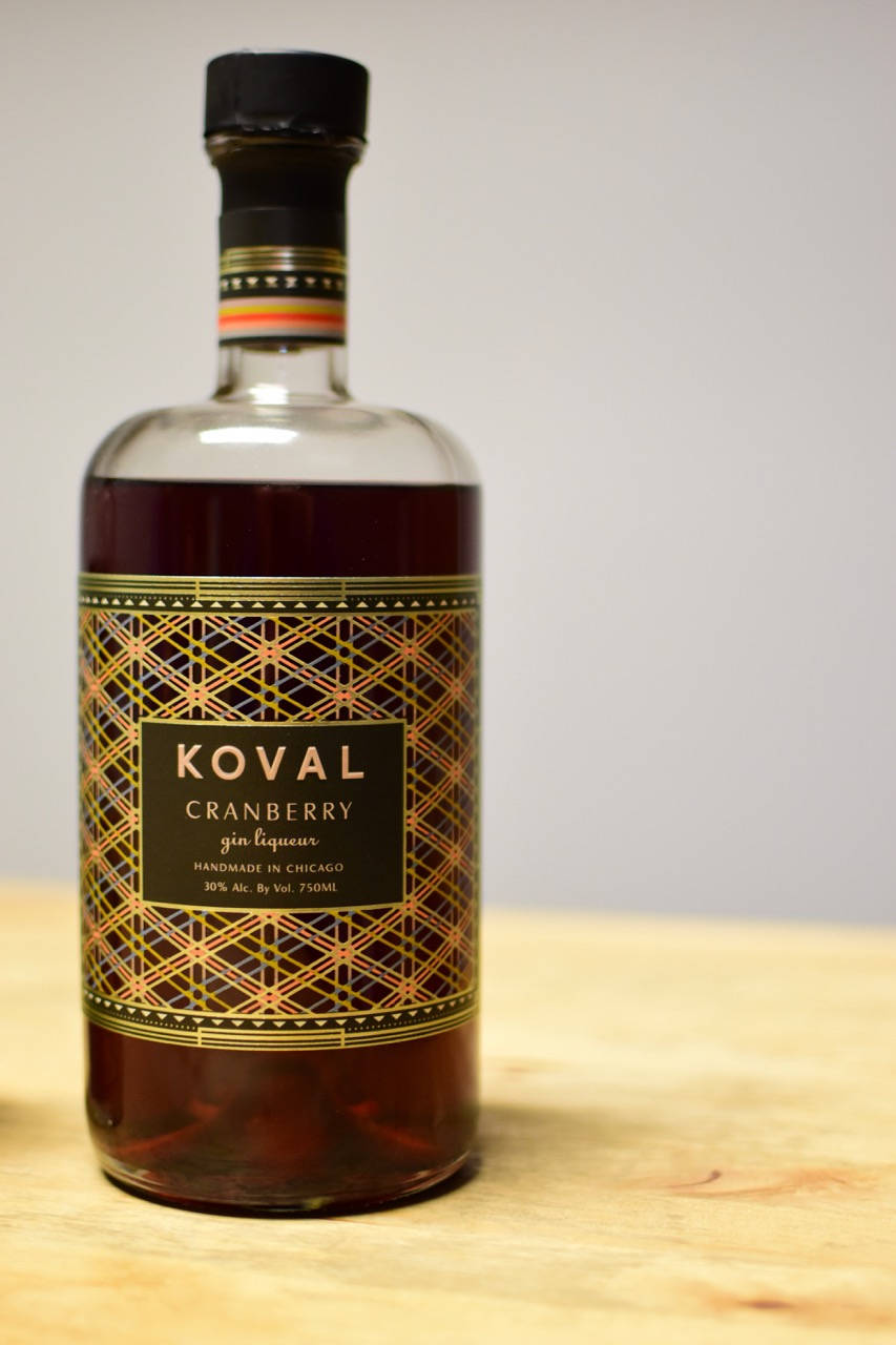 Koval蔓越莓琴酒利口酒瓶在木質表面上