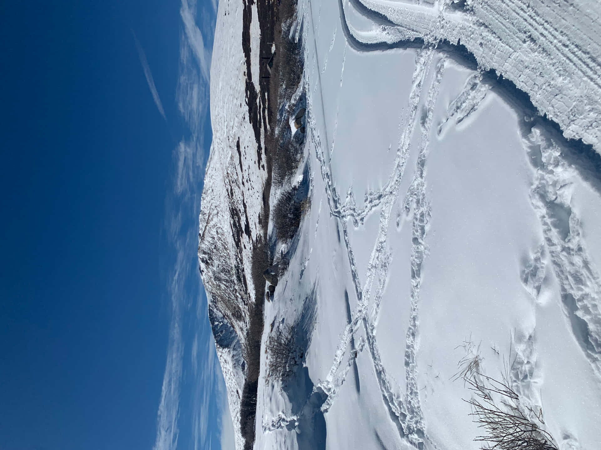 科羅拉多冬季 壁紙 — 晴朗藍天下，白雪覆蓋的山坡上滑雪道蜿蜒而下的鳥瞰圖。