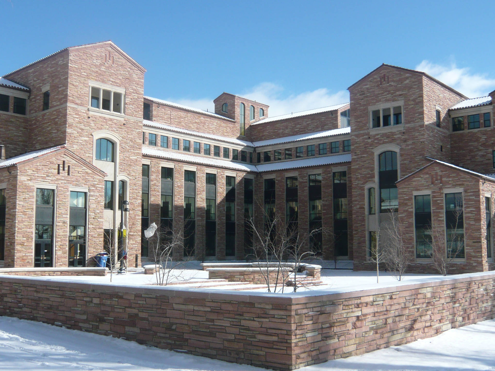 晴朗冬日裡被雪覆蓋的磚造大學建築。