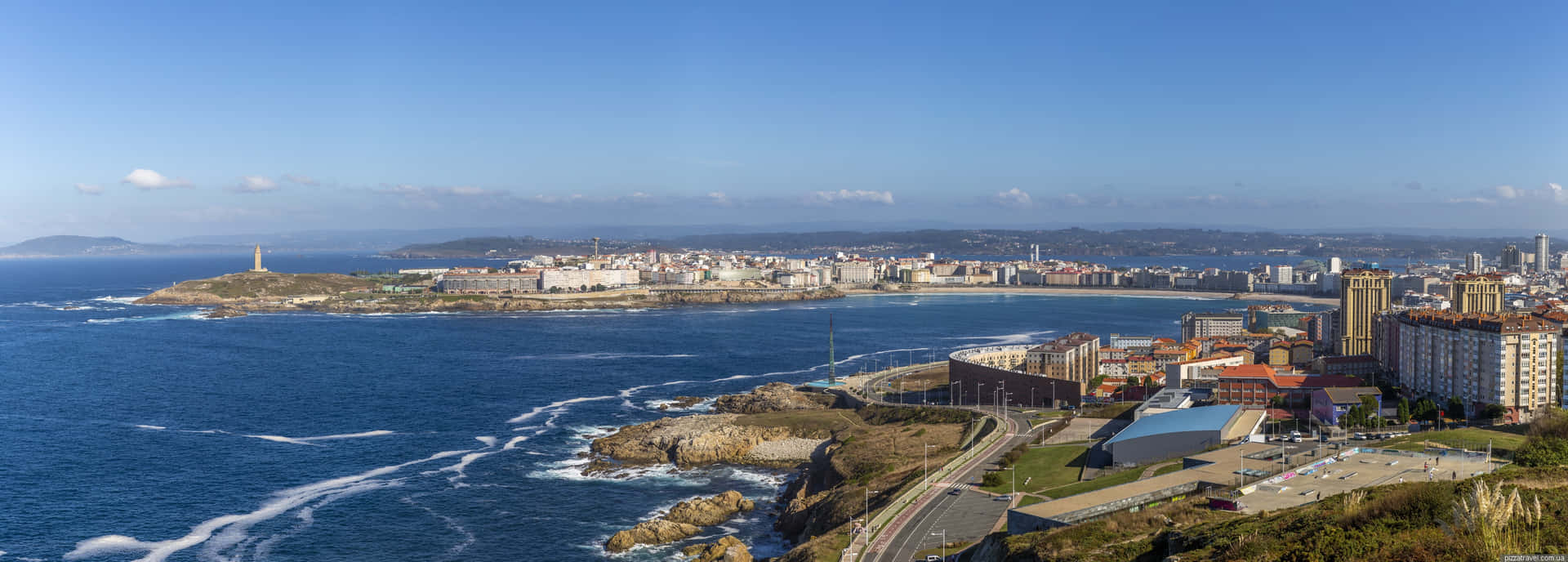 沿海城市，建築物沿著海岸線，海浪拍打岩石。