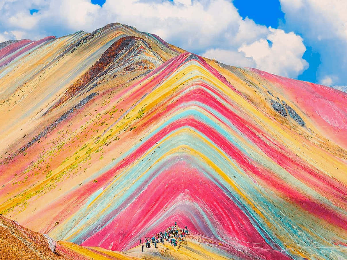 秘魯七彩山峰美景 壁紙 — 色彩鮮豔的條紋彩虹山，徒步旅行者在晴朗的藍天白雲下攀登。