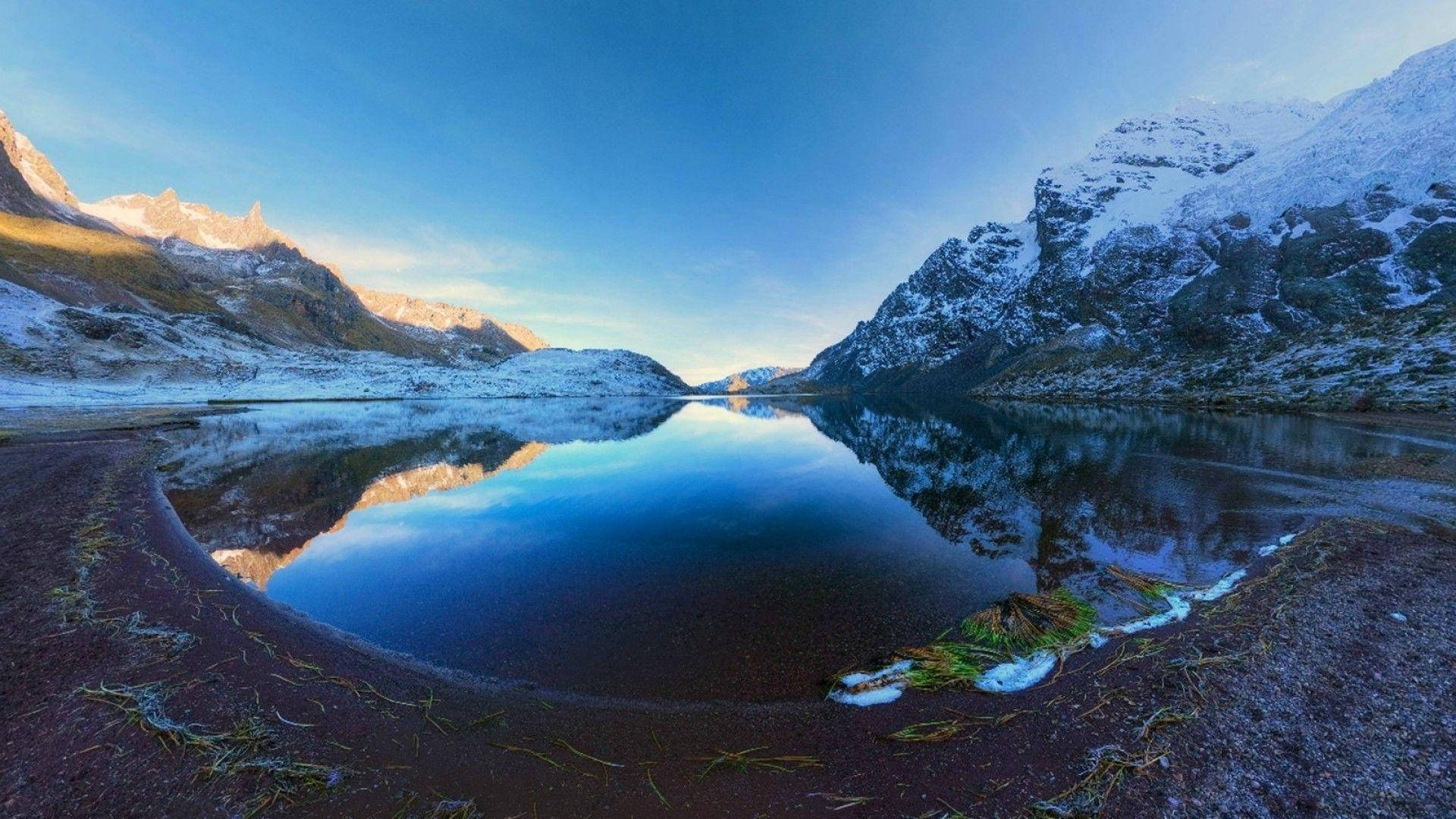 秘魯帕龍冰湖 壁紙 — 一個寧靜的雪山湖泊完美對稱地倒映著清澈的藍天和崎嶇的山峰。