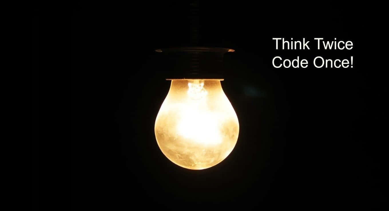 一個亮著的燈泡，上面有短語 Think Twice Code Once，背景為黑色。