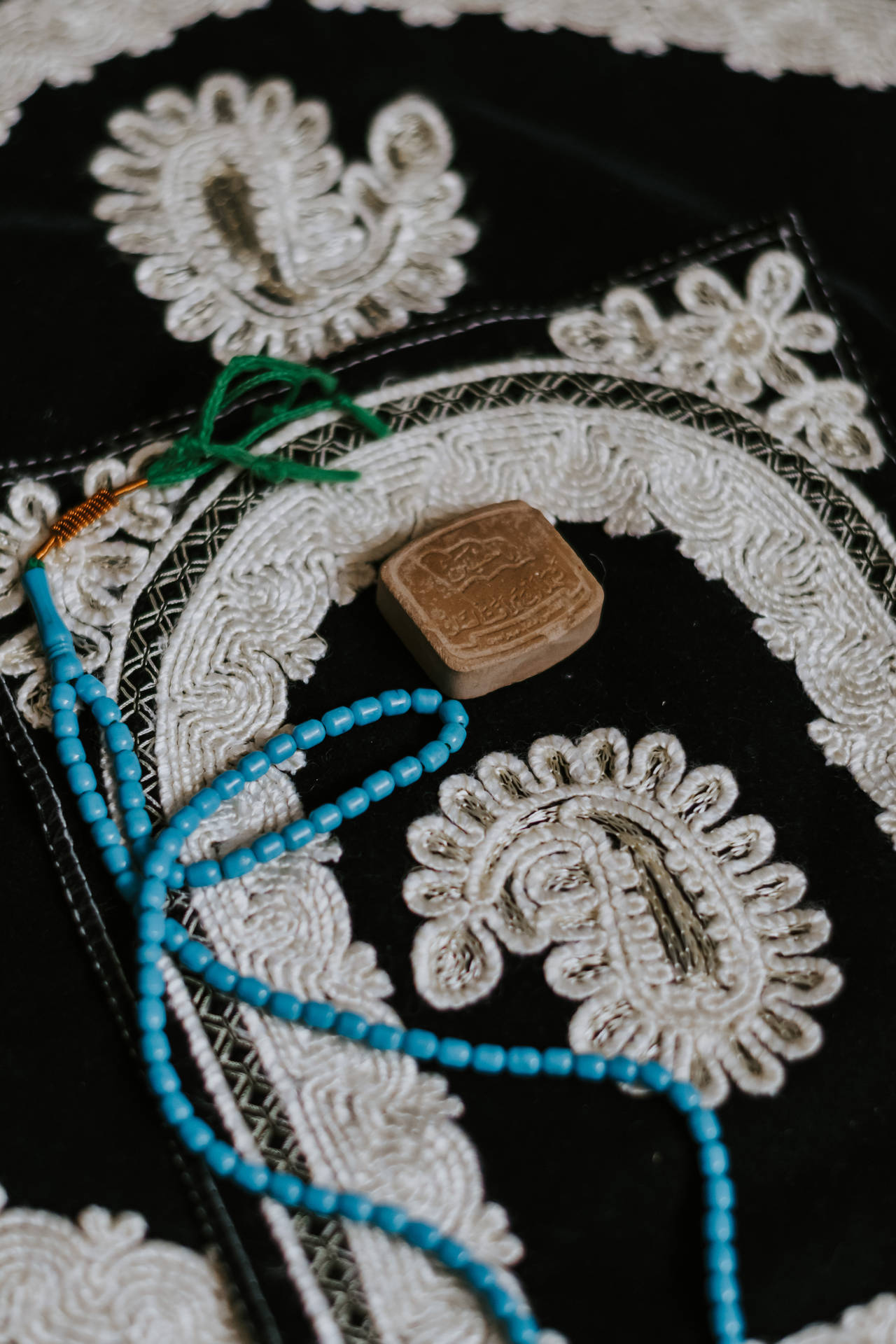 刺繡黑色布料上的綠松石珠和肥皂。