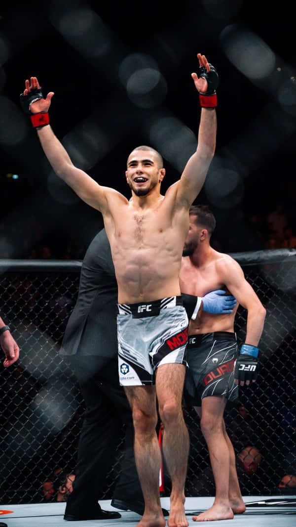 UFC拳手在八角籠內高舉雙臂慶祝勝利。