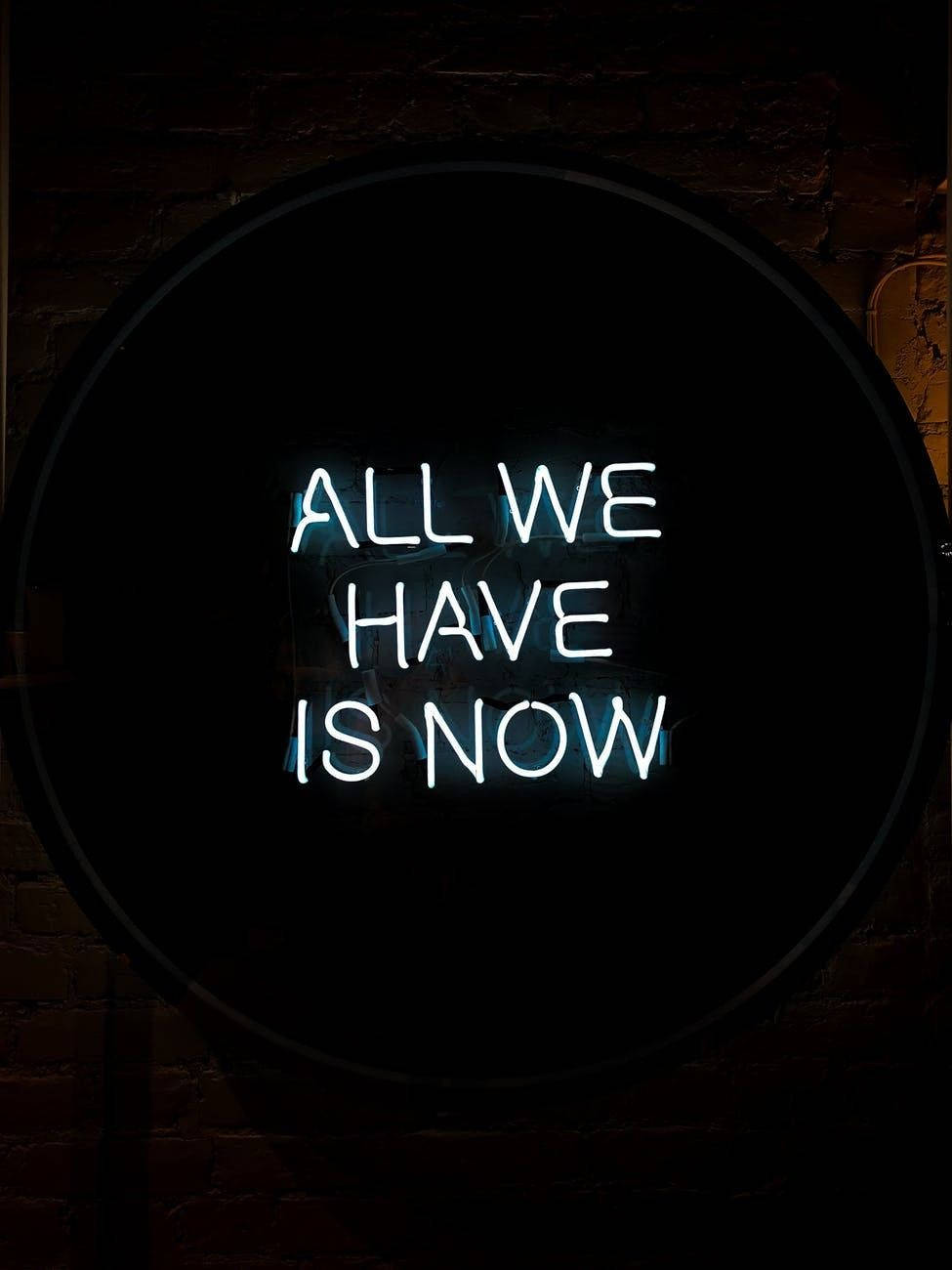 磚牆上帶有「All We Have Is Now」引文的霓虹燈牌