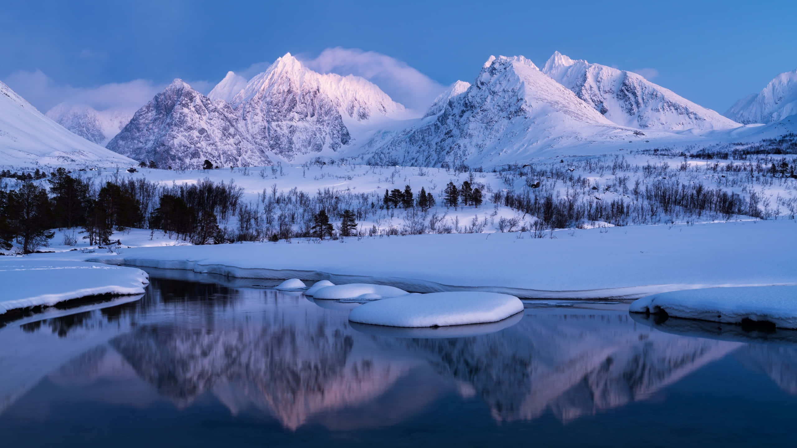 Snow Mountain 桌布 壁紙 — 積雪的山峰在暮色藍天下倒映在平靜的冰河上。