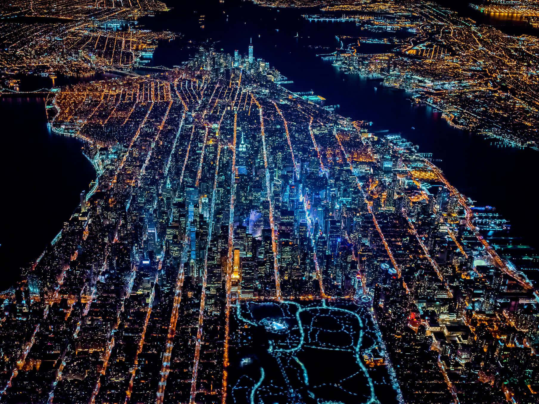 夜間鳥瞰圖，顯示明亮照明的城市網格，有水道和橋樑。