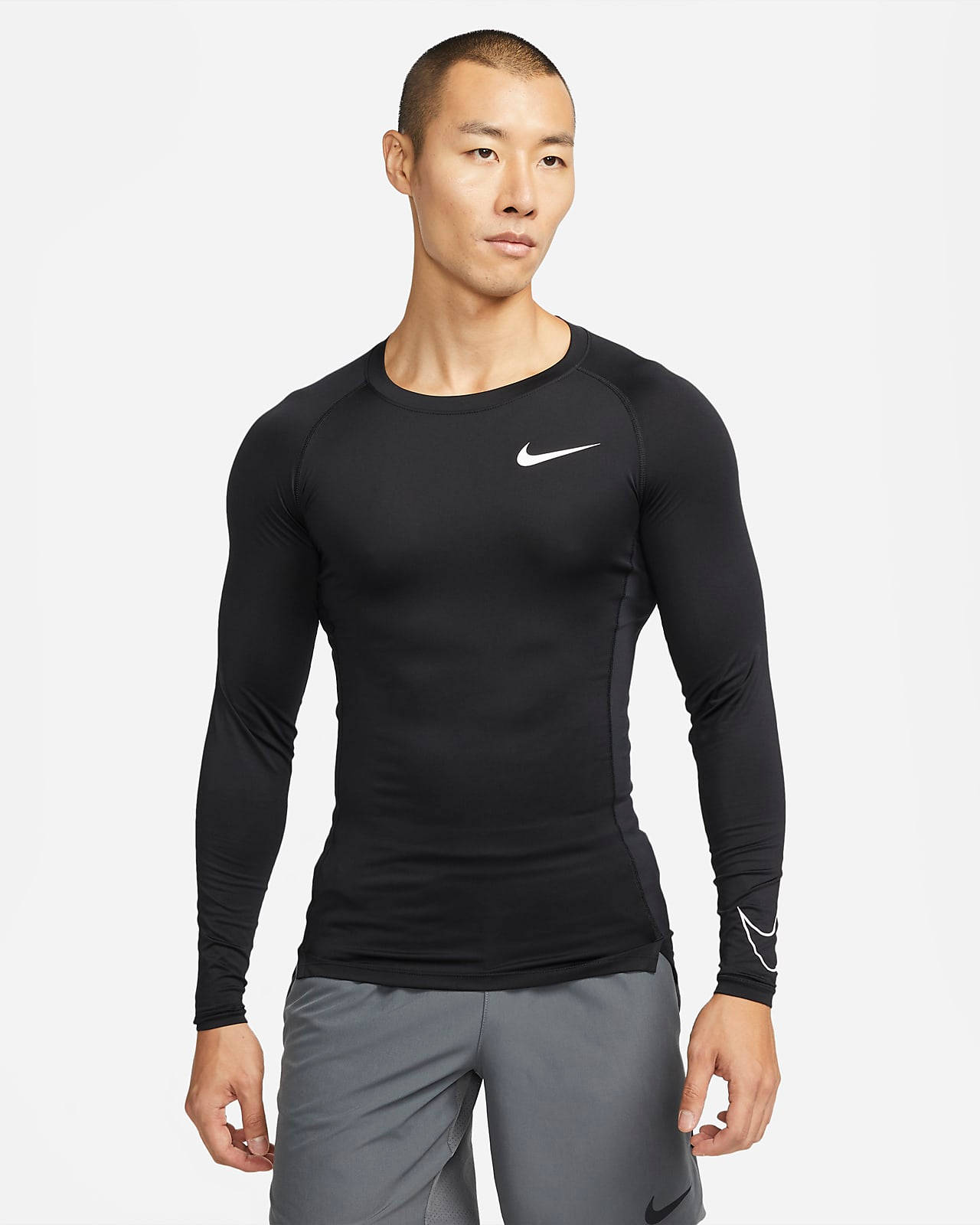男子身穿黑色Nike壓縮衫和灰色運動短褲。