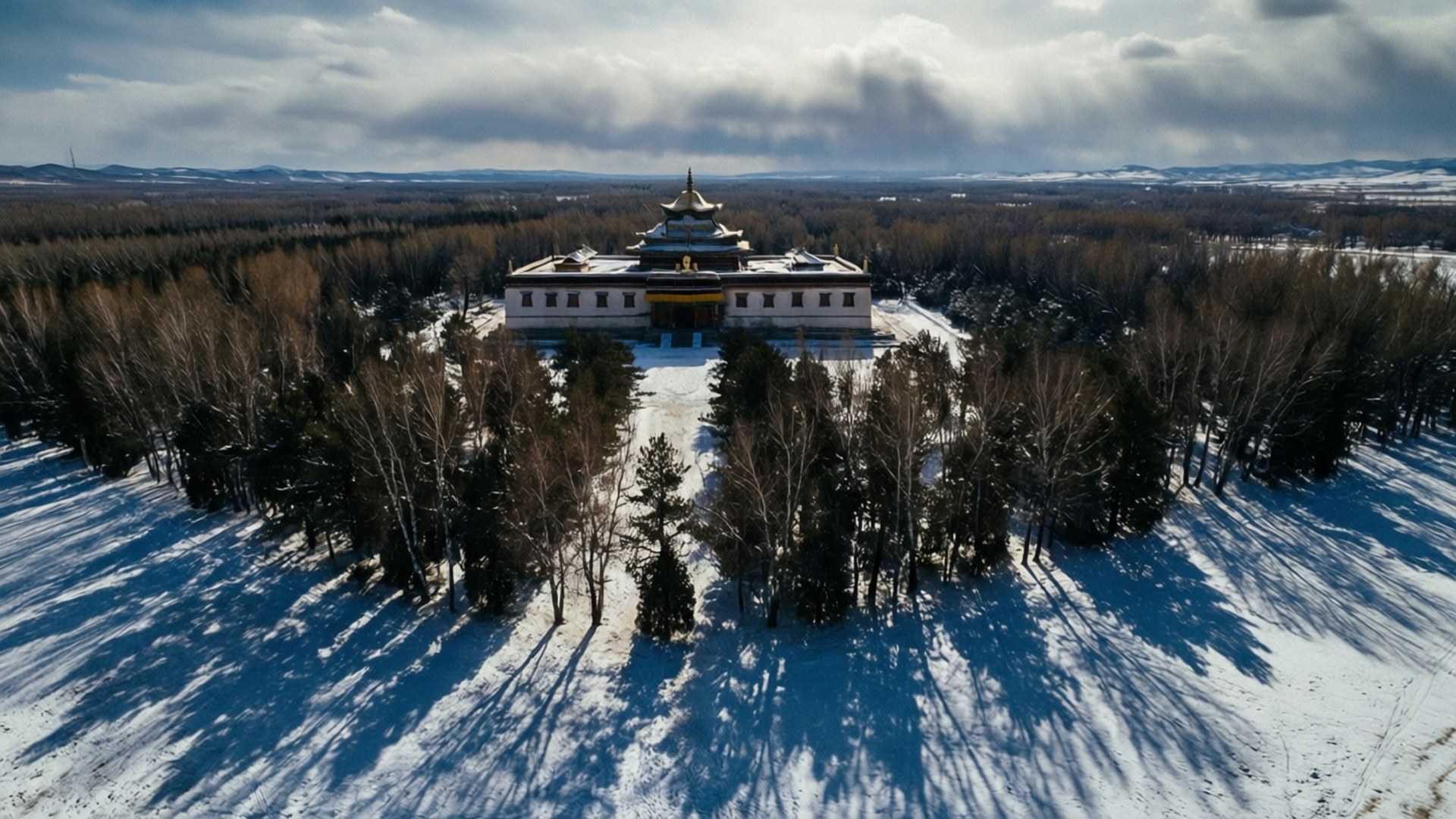 冬日景觀中，被白雪覆蓋的寺廟，周圍是光禿禿的樹木。