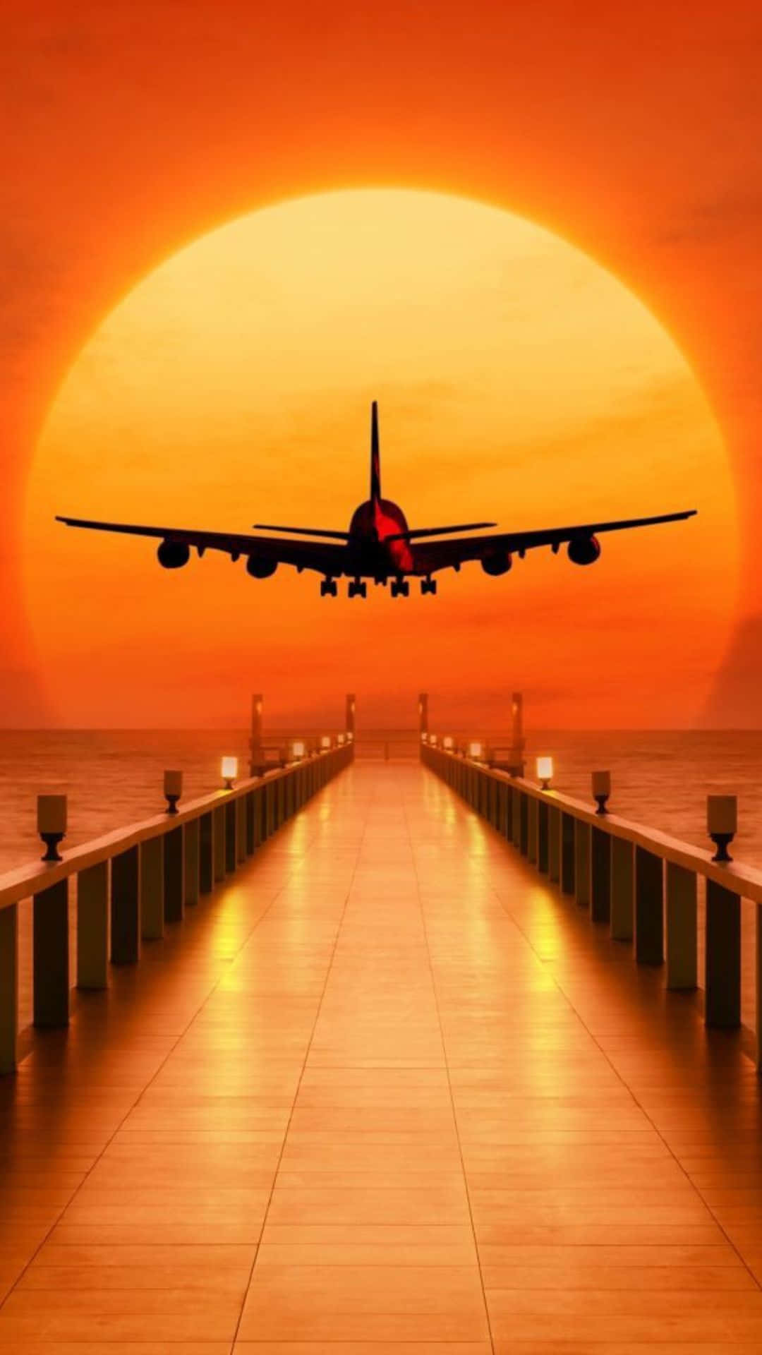 空中飛行的小型飛機 壁紙 — 一架大型飛機正降落在發光的橙色日落中，接近一條延伸在平靜水面上嘅長碼頭。