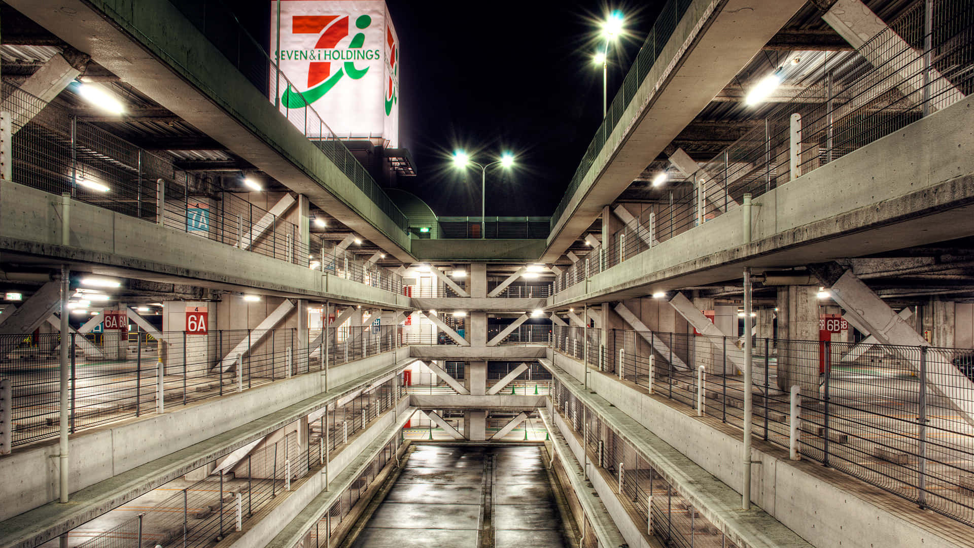 夜晚的多層混凝土停車場，帶有發光標誌和空位。
