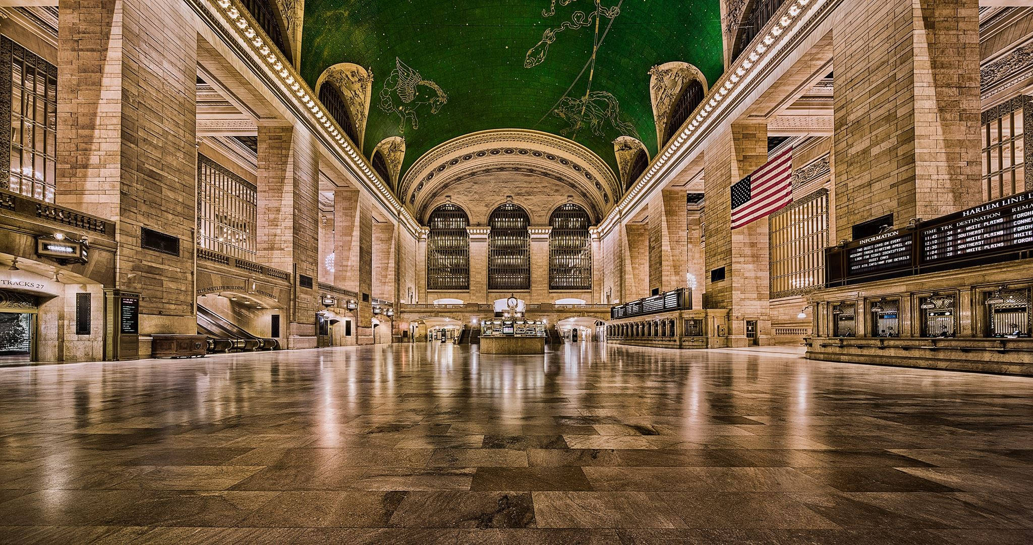 空無一人的中央車站 壁紙 — 宏偉的石造火車站大廳，帶有綠色天穹天花板和拋光瓷磚地板，反射著溫暖的燈光。