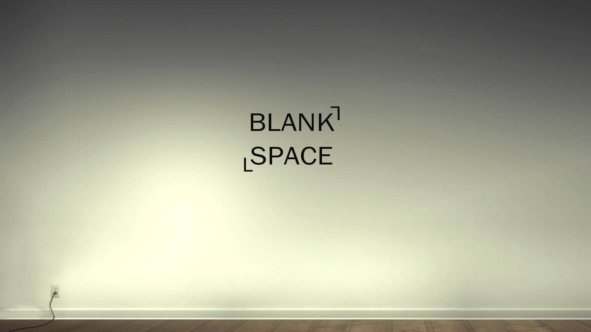 白色牆壁上的 Blank space 文字，配有聚光燈和木地板。