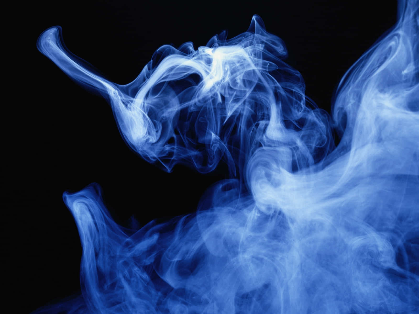 Smoke Blue 桌布 壁紙 — 空靈的藍色煙霧在純黑色背景上動態旋轉，營造出迷人的抽象形態。