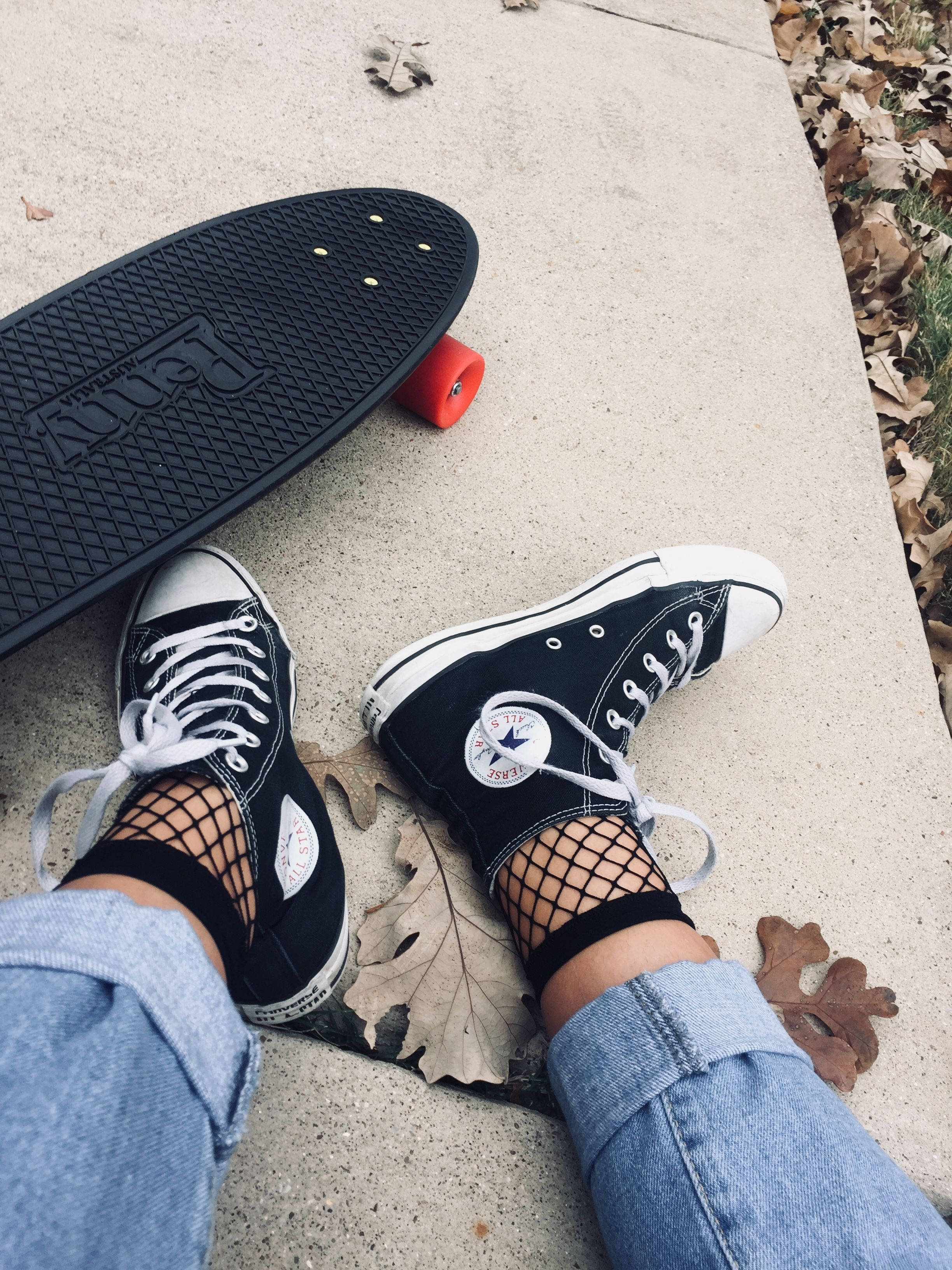 穿 Converse 鞋與網襪的滑板女孩，滑板風格 壁紙 — 特寫鏡頭：黑色Converse鞋和魚網襪的腳，旁邊放著一塊Penny滑板，在人行道上散落著乾樹葉。