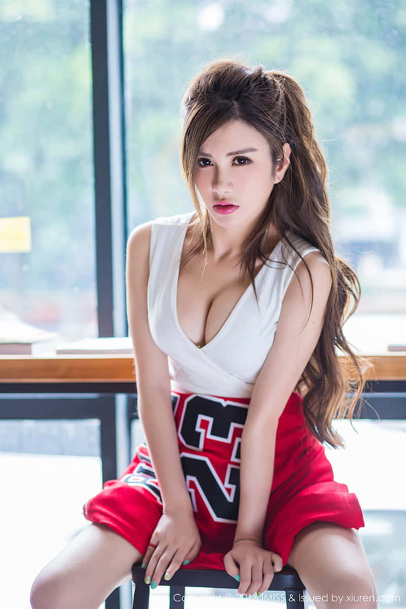 穿著啦啦隊服裝的女性在室內窗邊坐著