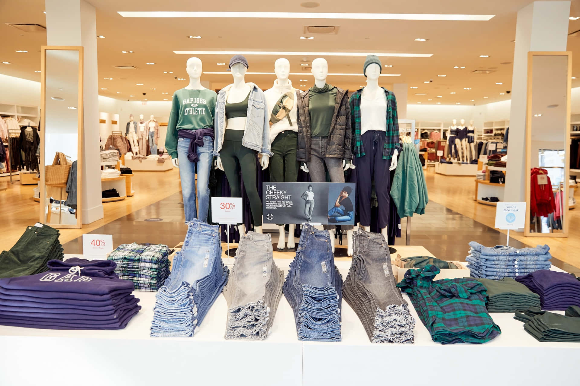 零售店中展示穿著休閒服飾、牛仔褲和格仔襯衫的人體模型。