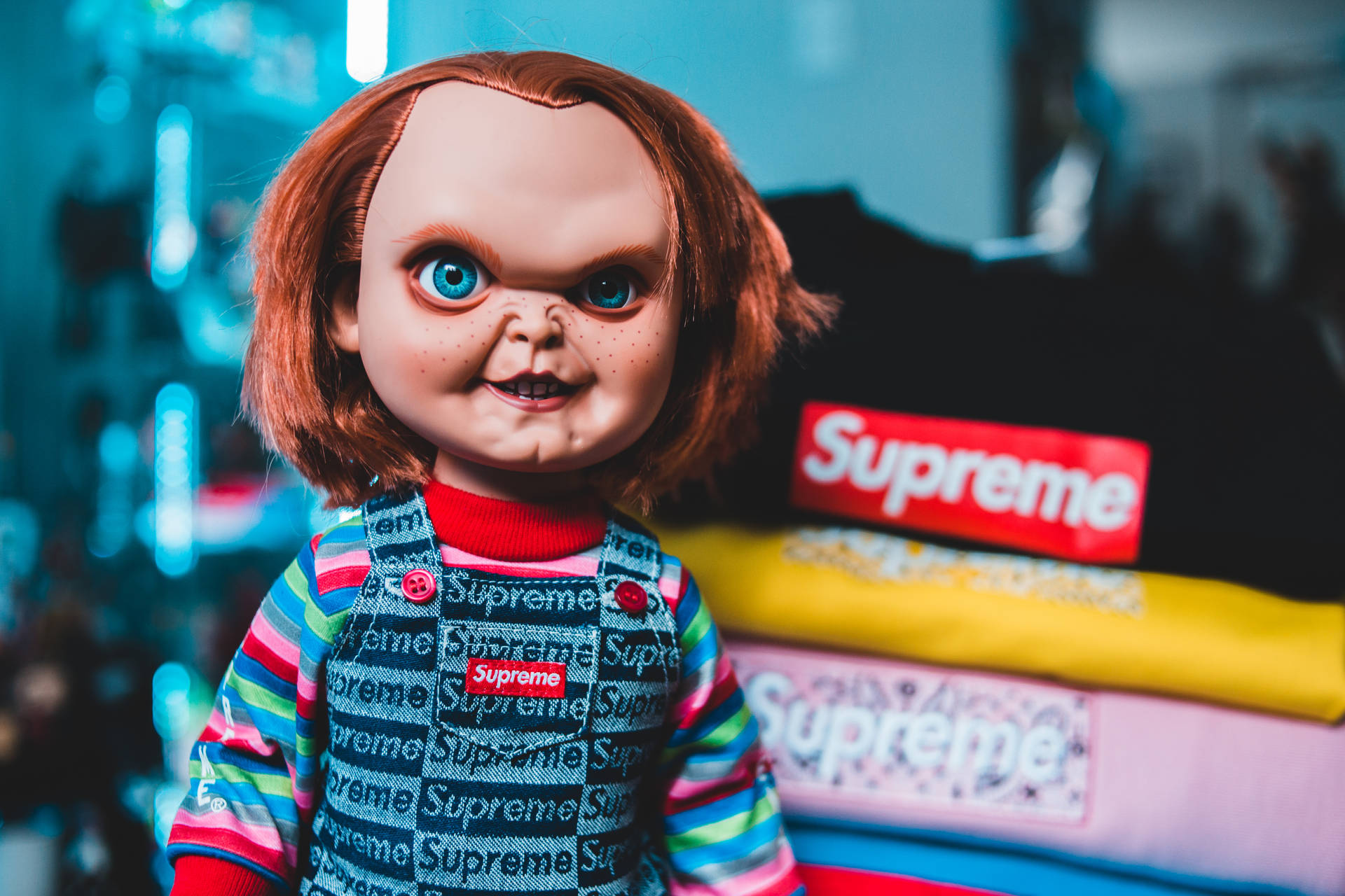Chucky 公仔穿著 Supreme 衫，後面有霓虹燈。