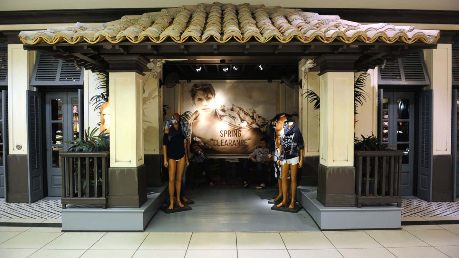 零售展示，人體模型在瓷磚屋頂下宣傳春季清倉。