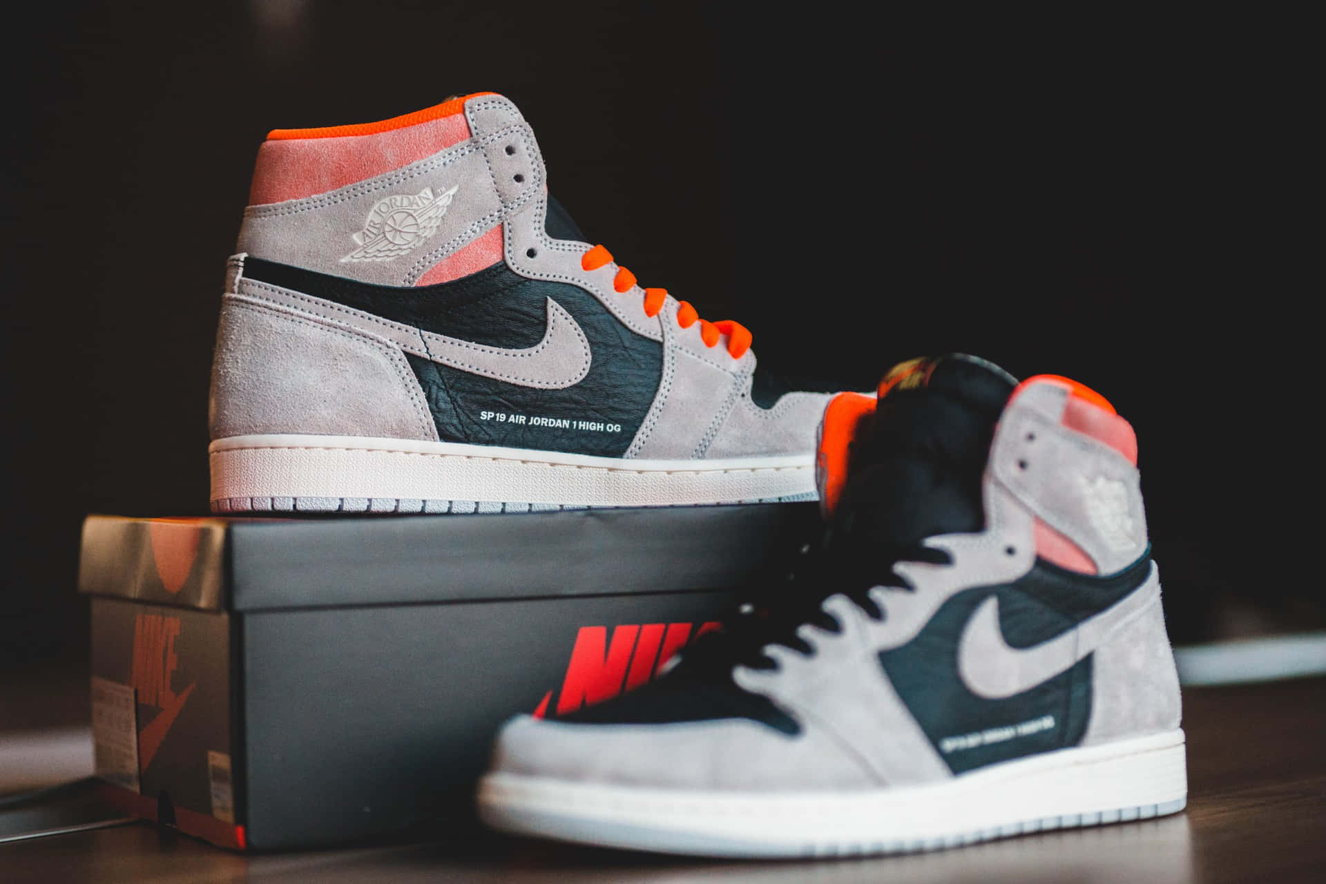 灰黑橙色的 Air Jordan 1 運動鞋放在 Nike 鞋盒上。