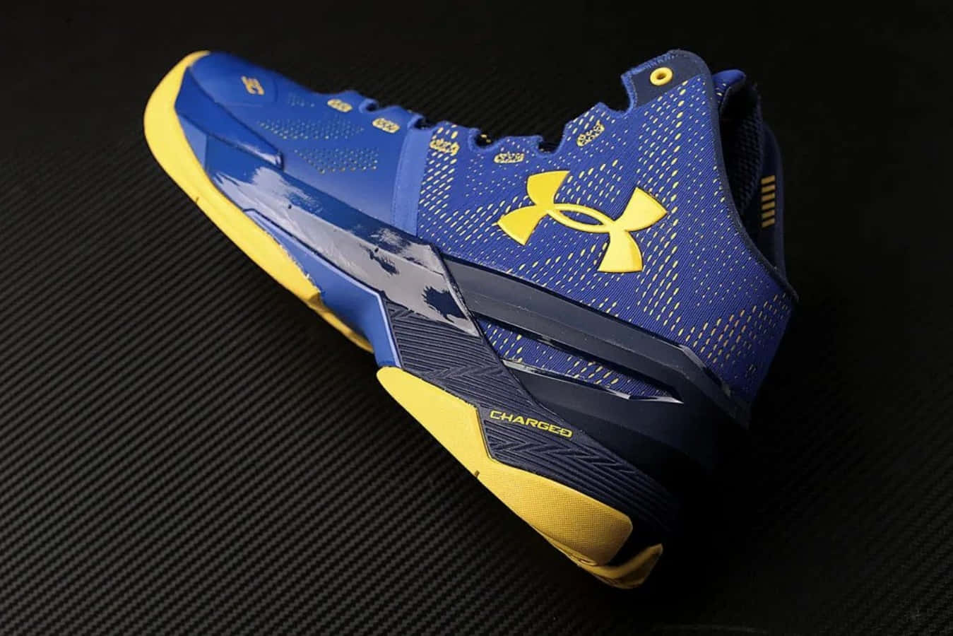 藍黃色 Under Armour 籃球鞋在碳纖維背景上