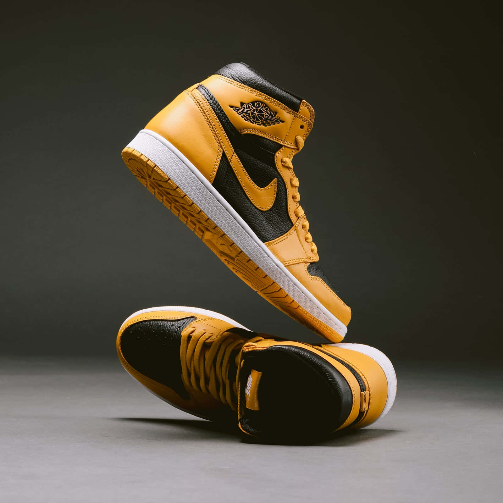 黑色和金色的Air Jordan 1運動鞋在攝影棚環境中漂浮。