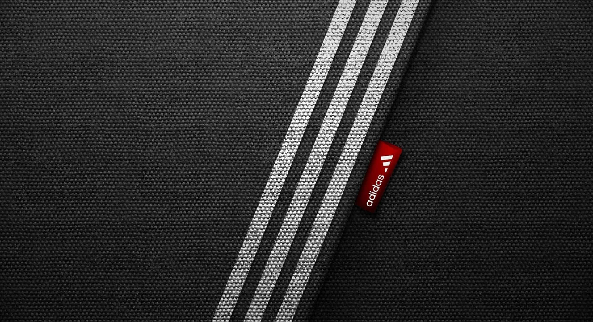 帶有白色條紋和紅色adidas標籤的黑色運動布料。