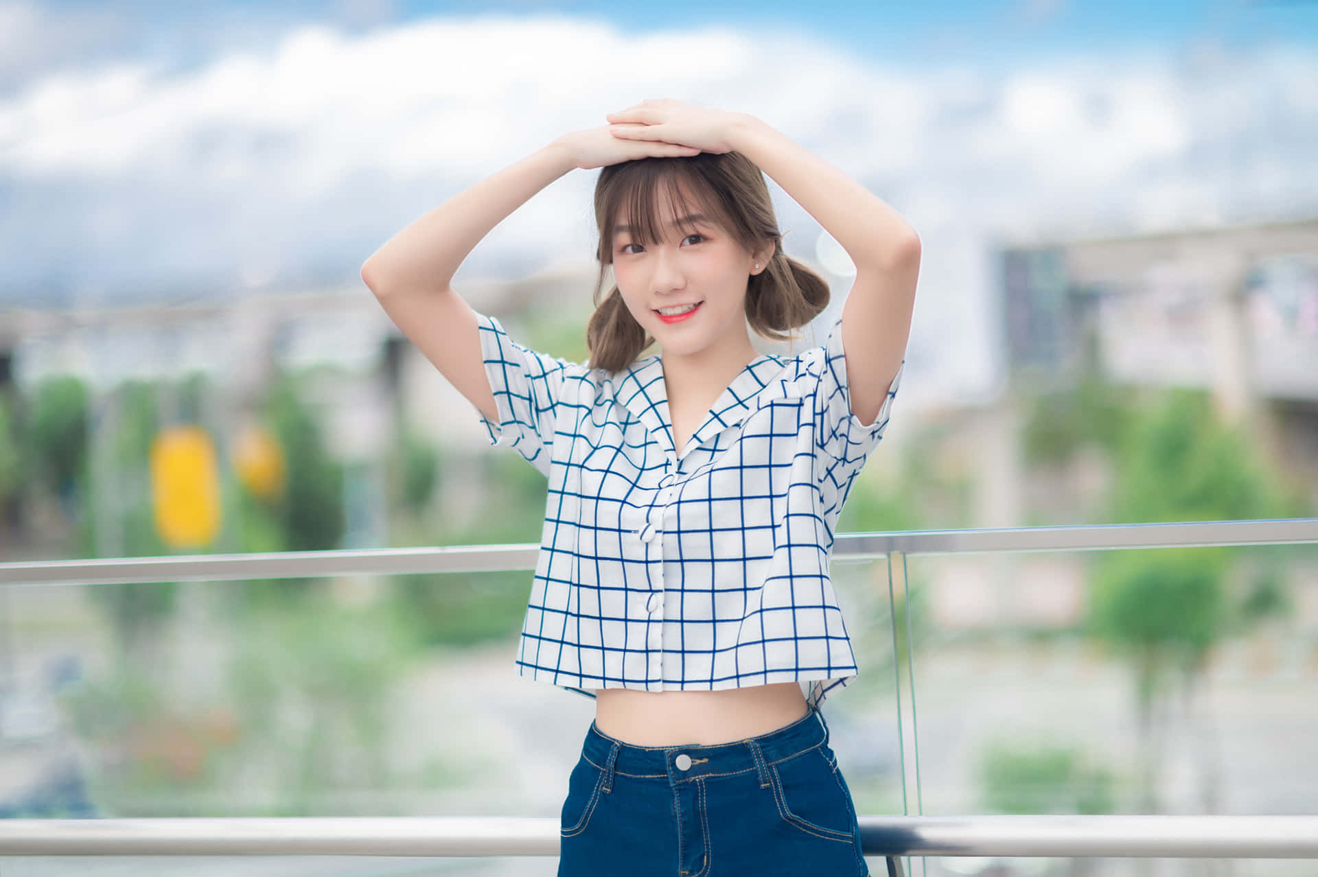 身穿格仔恤衫的年輕女性在陽光燦爛的陽台上微笑