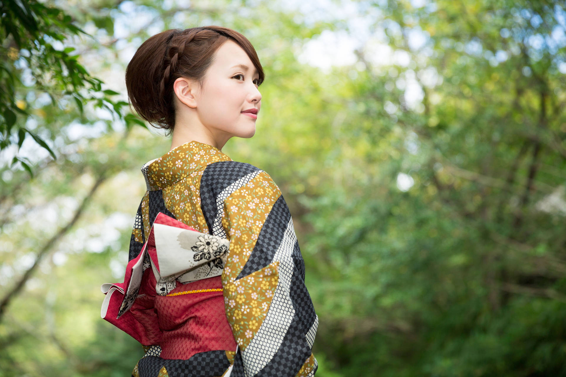 傳統和服女人在陽光明媚的日子裡站在森林中。
