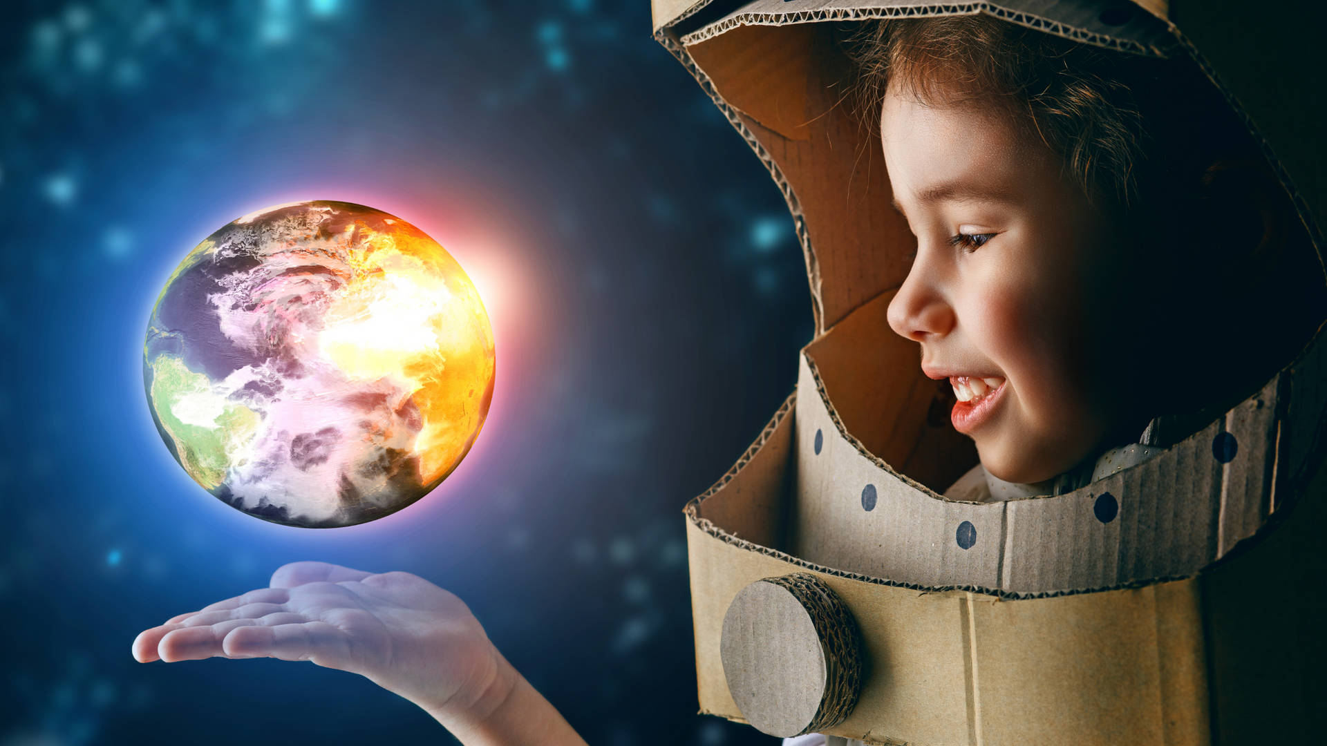 穿著紙板太空衣的小孩抱著發光的地球在太空中。