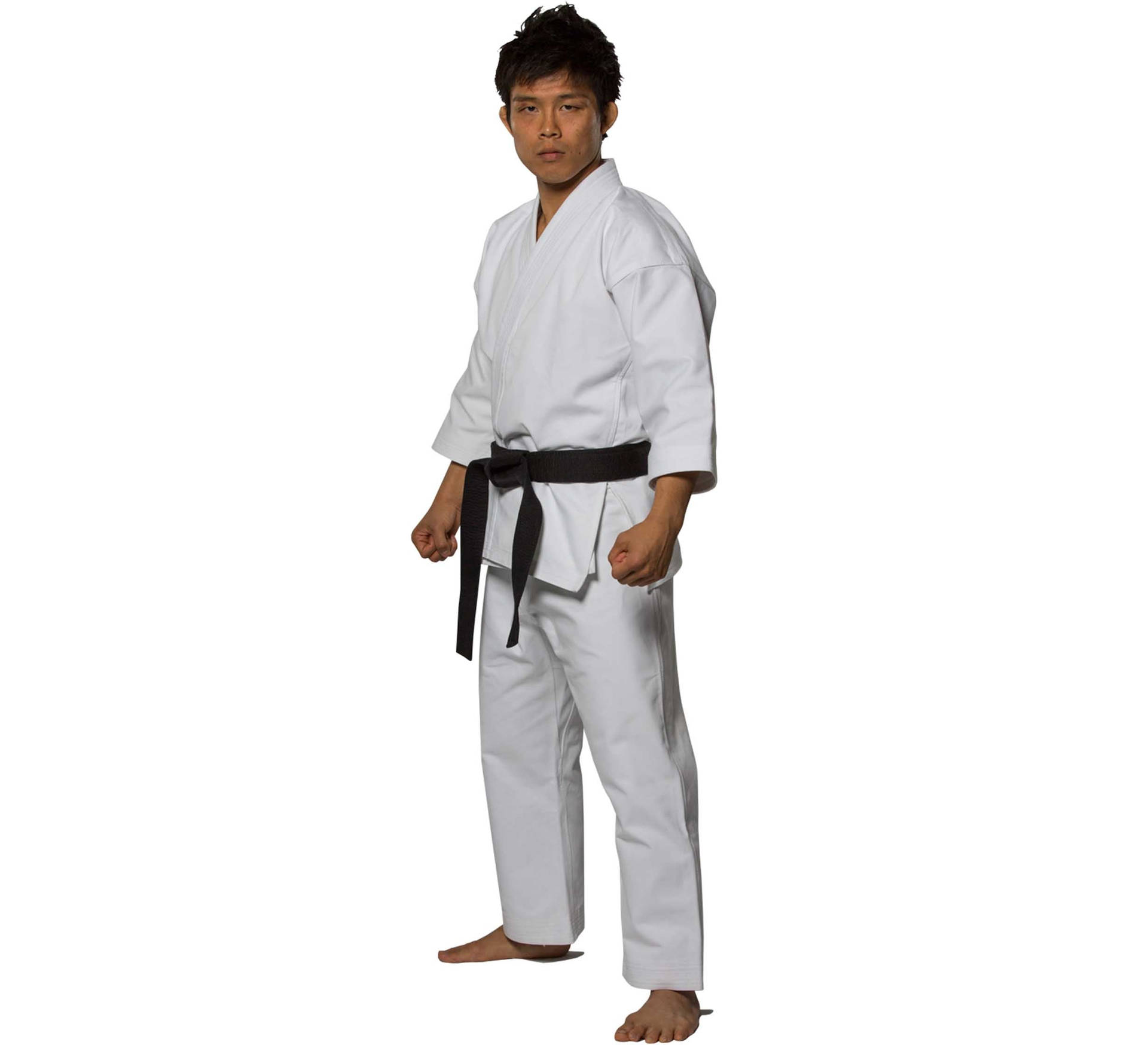 年輕男子身穿白色空手道服，繫黑色腰帶，赤腳站立。