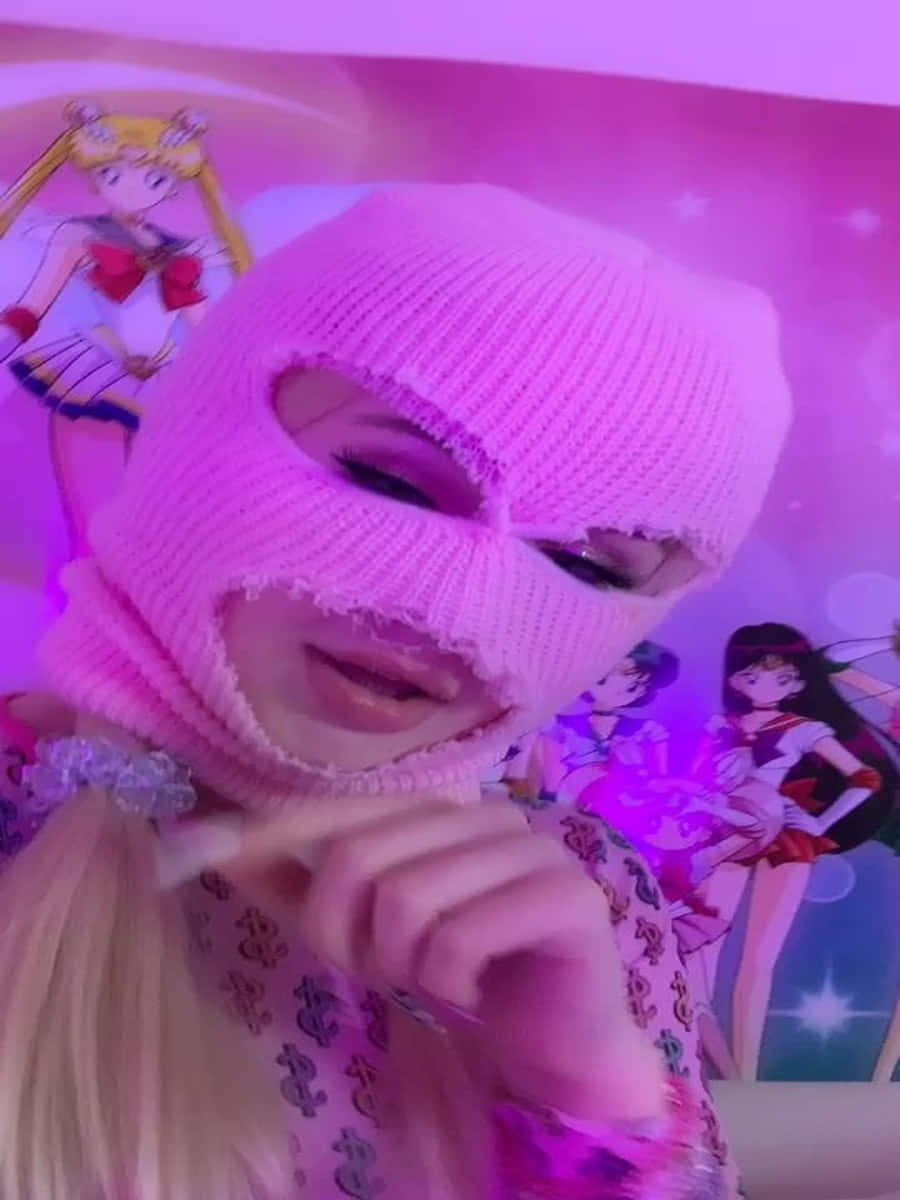 戴住粉紅色巴拉克拉法帽嘅人喺美少女戰士牆紙前面。