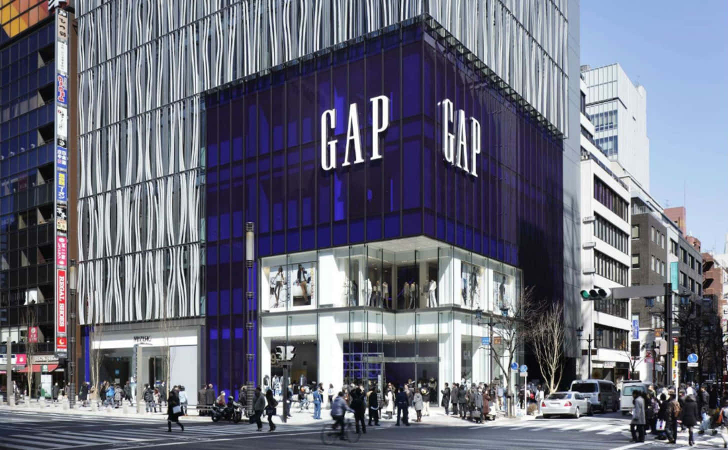 繁忙都市街道上的藍色玻璃GAP商店，有行人和汽車。