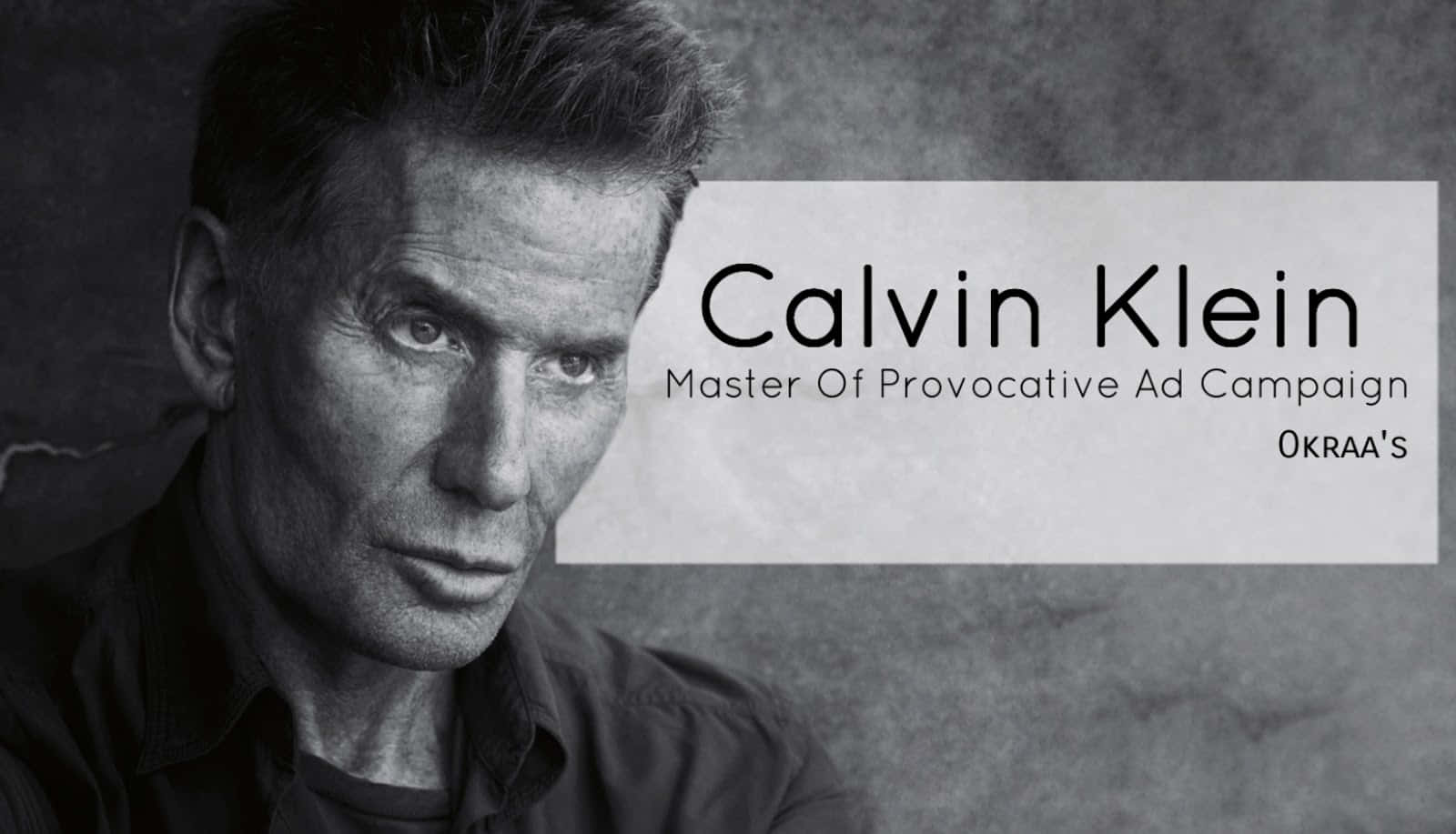 穿著Calvin Klein，保持時尚品味 壁紙 — 一個黑白肖像，男人眼神銳利，背景為帶紋理的灰色，並帶有Calvin Klein品牌標誌。