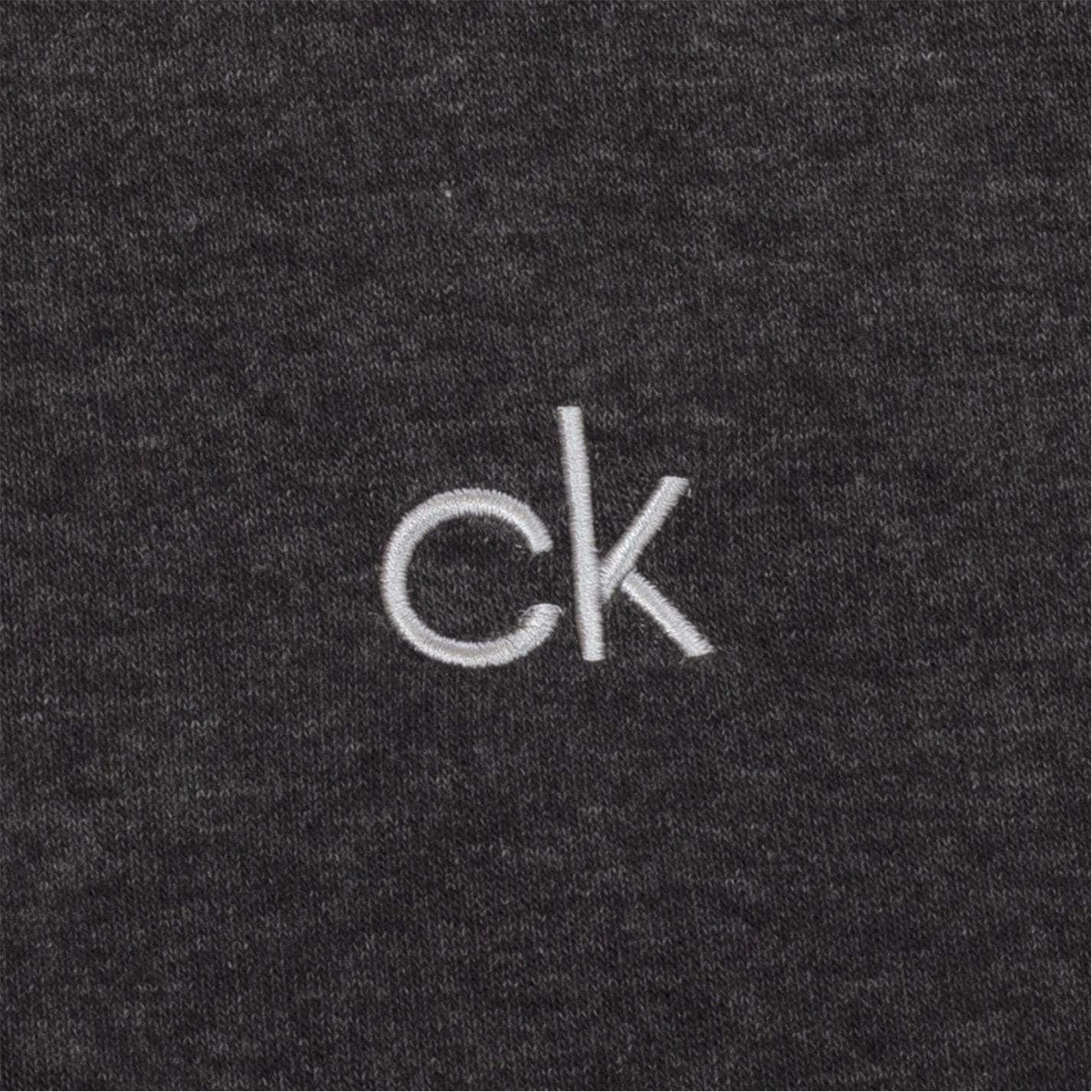穿著Calvin Klein，自信出眾 壁紙 — 白色刺繡CK標誌在深麻灰色紋理布料上的特寫。