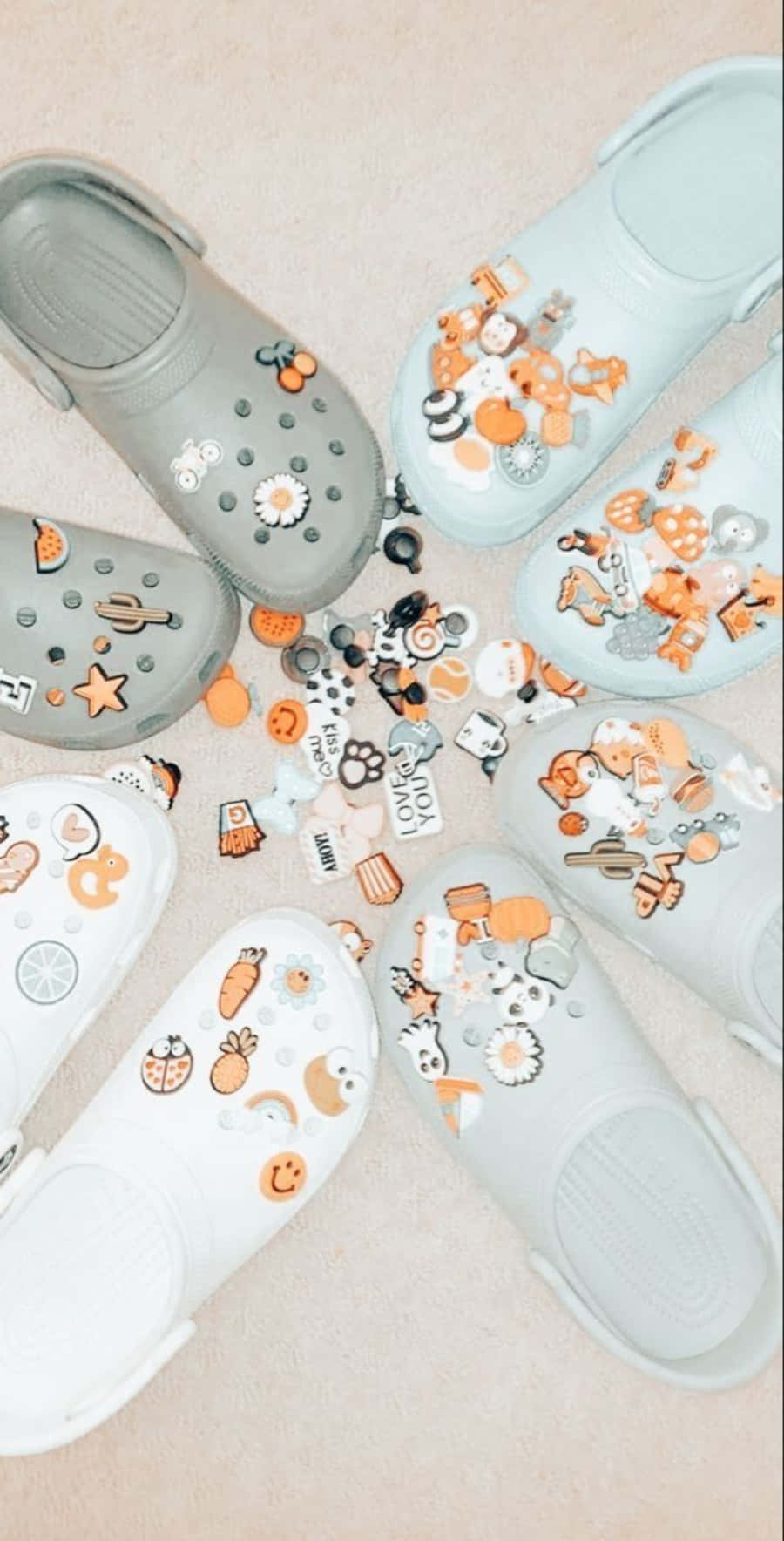 柔和粉彩Crocs飾以秋季吊飾，在米色地板上排列成圓形。