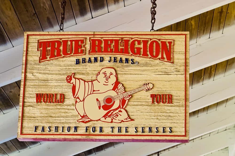 True Religion牛仔褲木製招牌，帶有彈結他的佛陀，懸掛在室內。