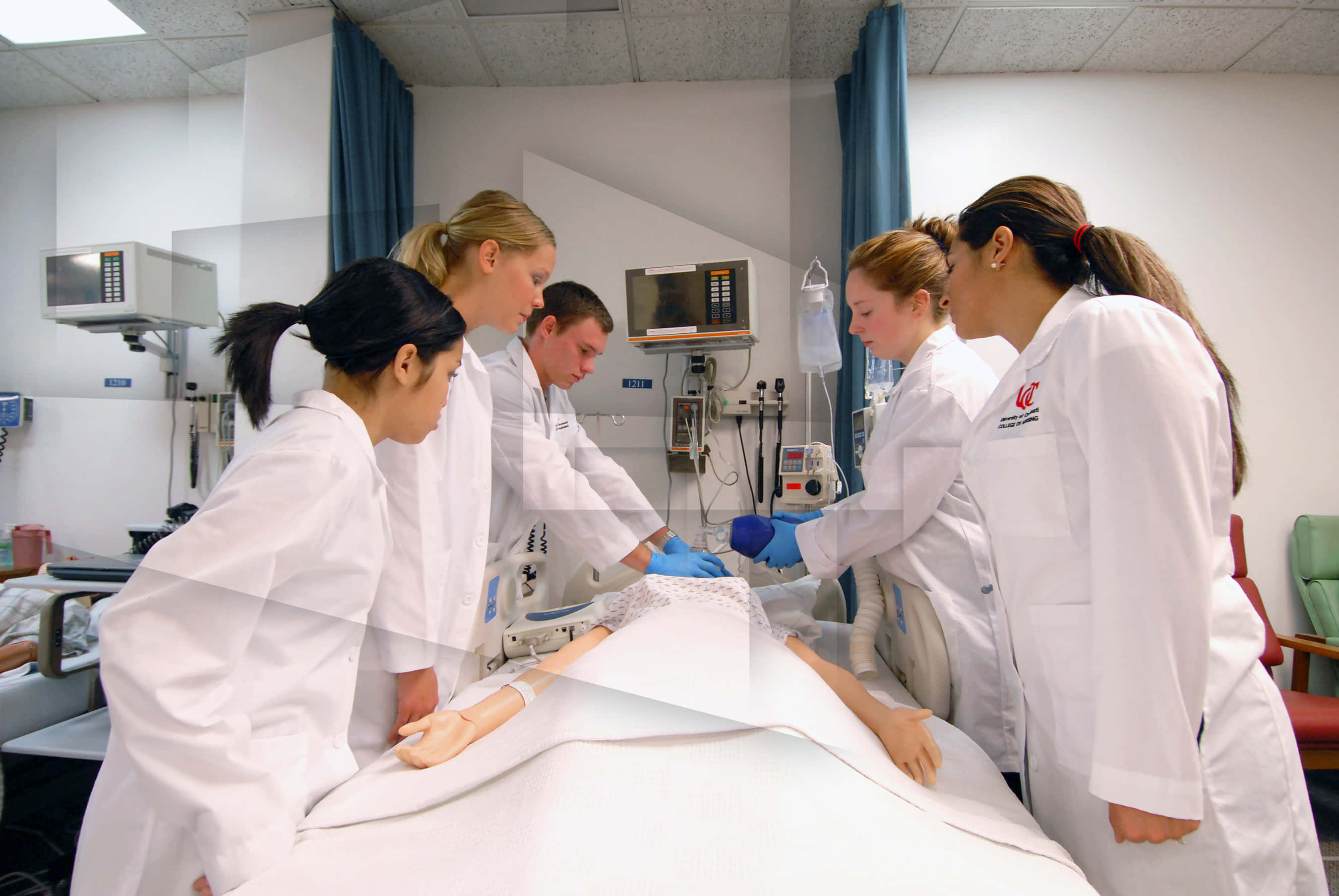 Nursing 桌布 壁紙 — 穿著白袍的醫學生在臨床訓練室中對病人模型進行程序練習。