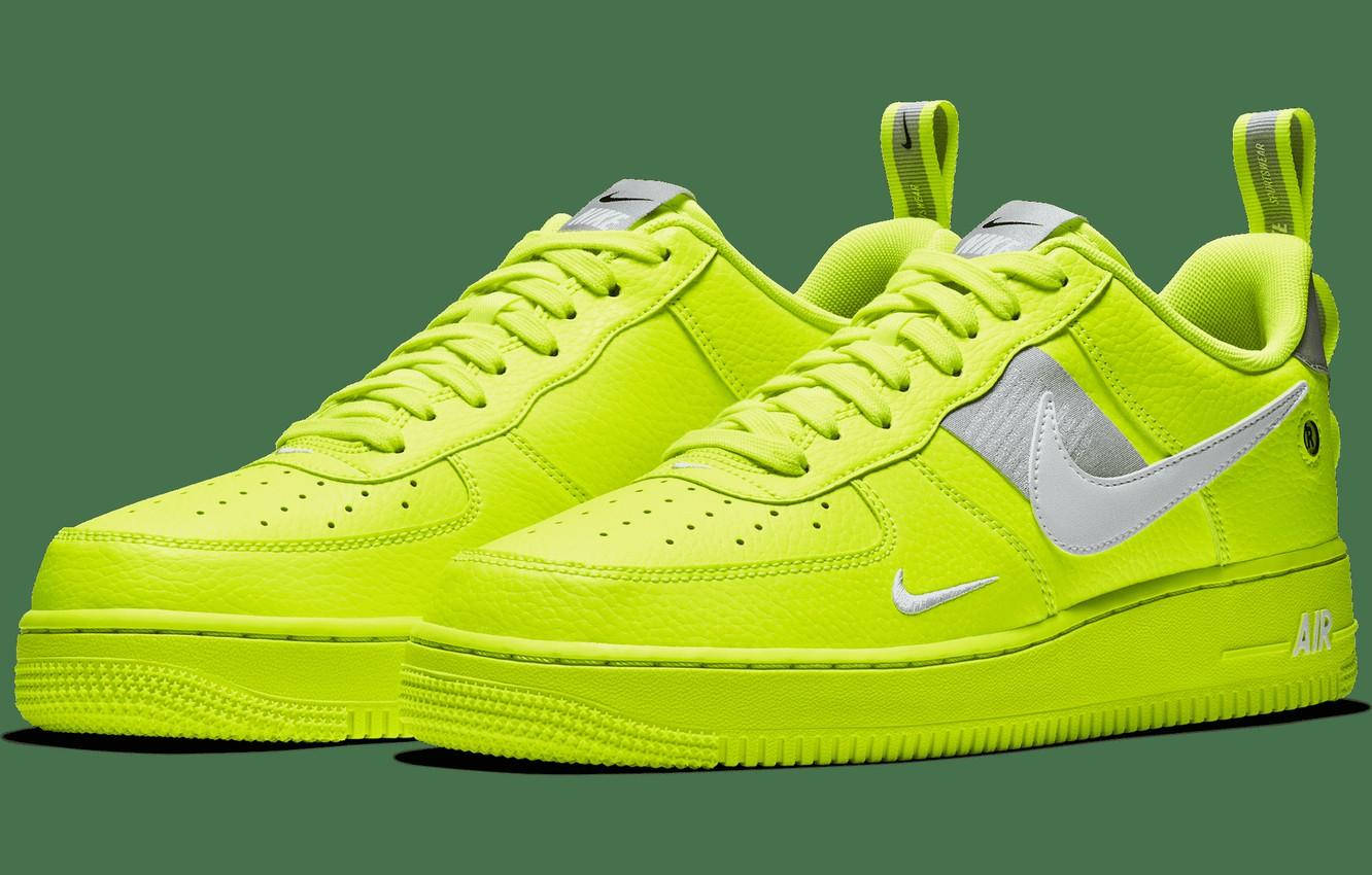 螢光黃色Nike Air Force 1運動鞋，帶有銀色點綴，以綠色背景襯托。