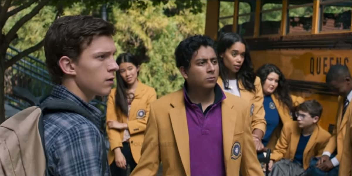 Flash Thompson 桌布 壁紙 — 穿著黃色校服外套的青少年站在樹木林立的城市環境中，靠近一輛黃色校車。