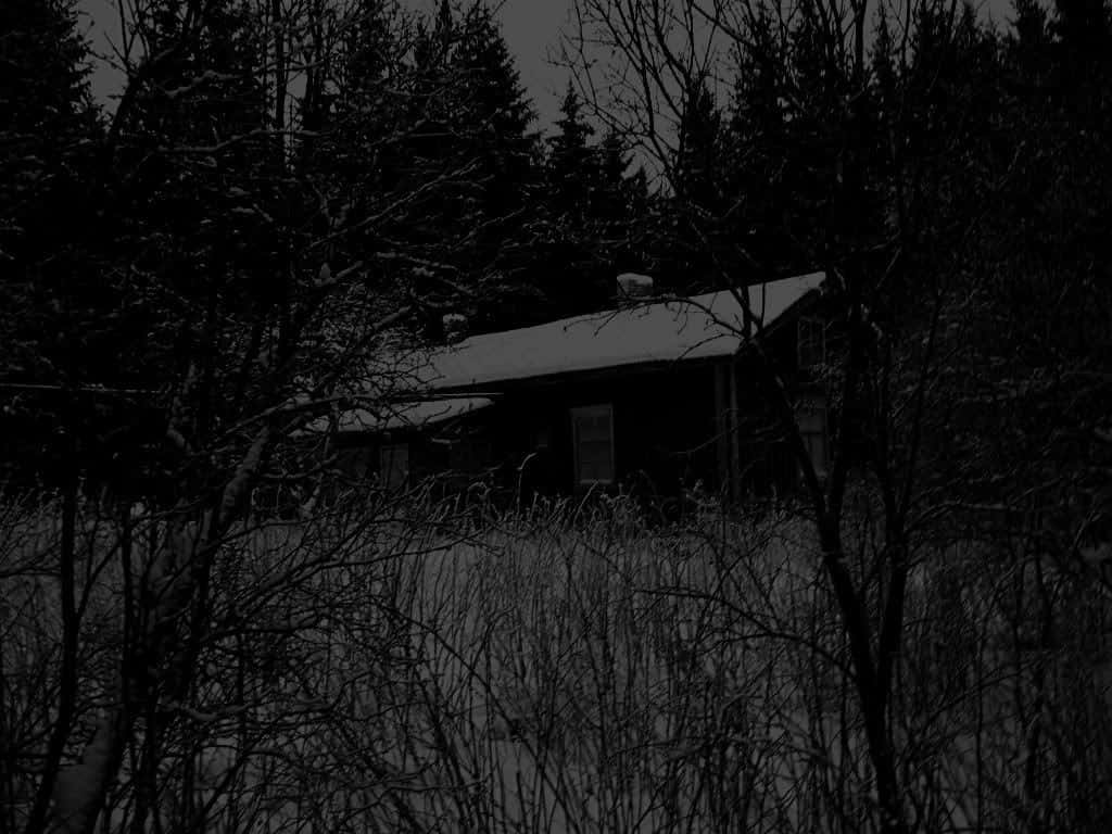 夜晚雪地森林中的黑暗小屋。