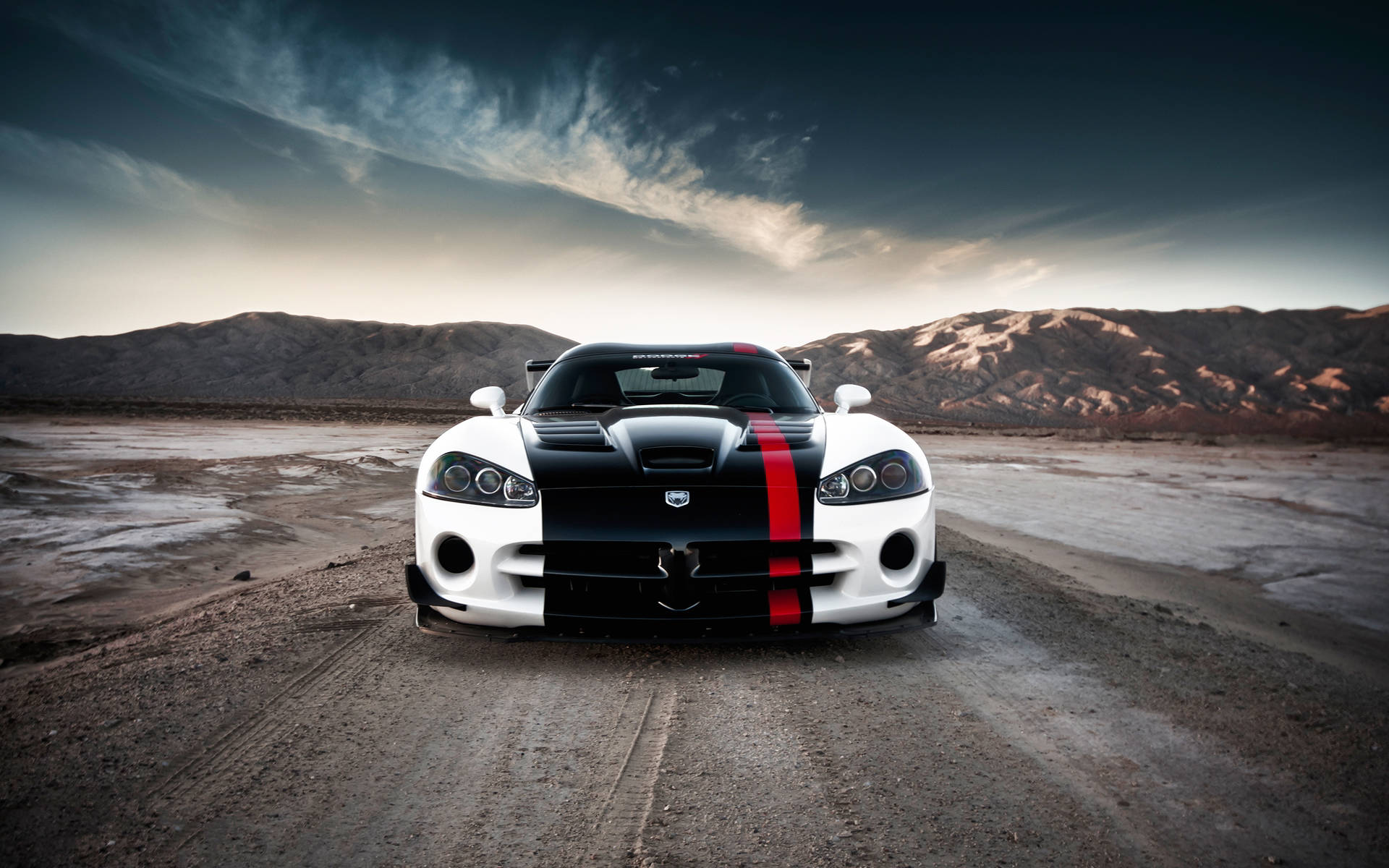 黃昏時分沙漠道路上的白色和黑色道奇Viper，帶有紅色條紋。