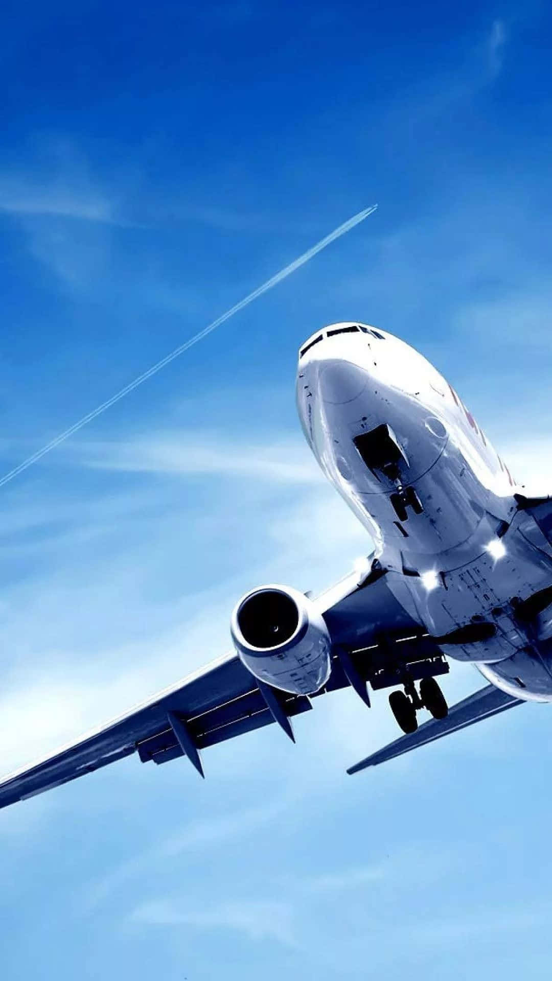 穿越雲層的旅程 壁紙 — 一架商用飛機在晴朗的藍天中向上飛升，留下一道白色凝結尾跡。