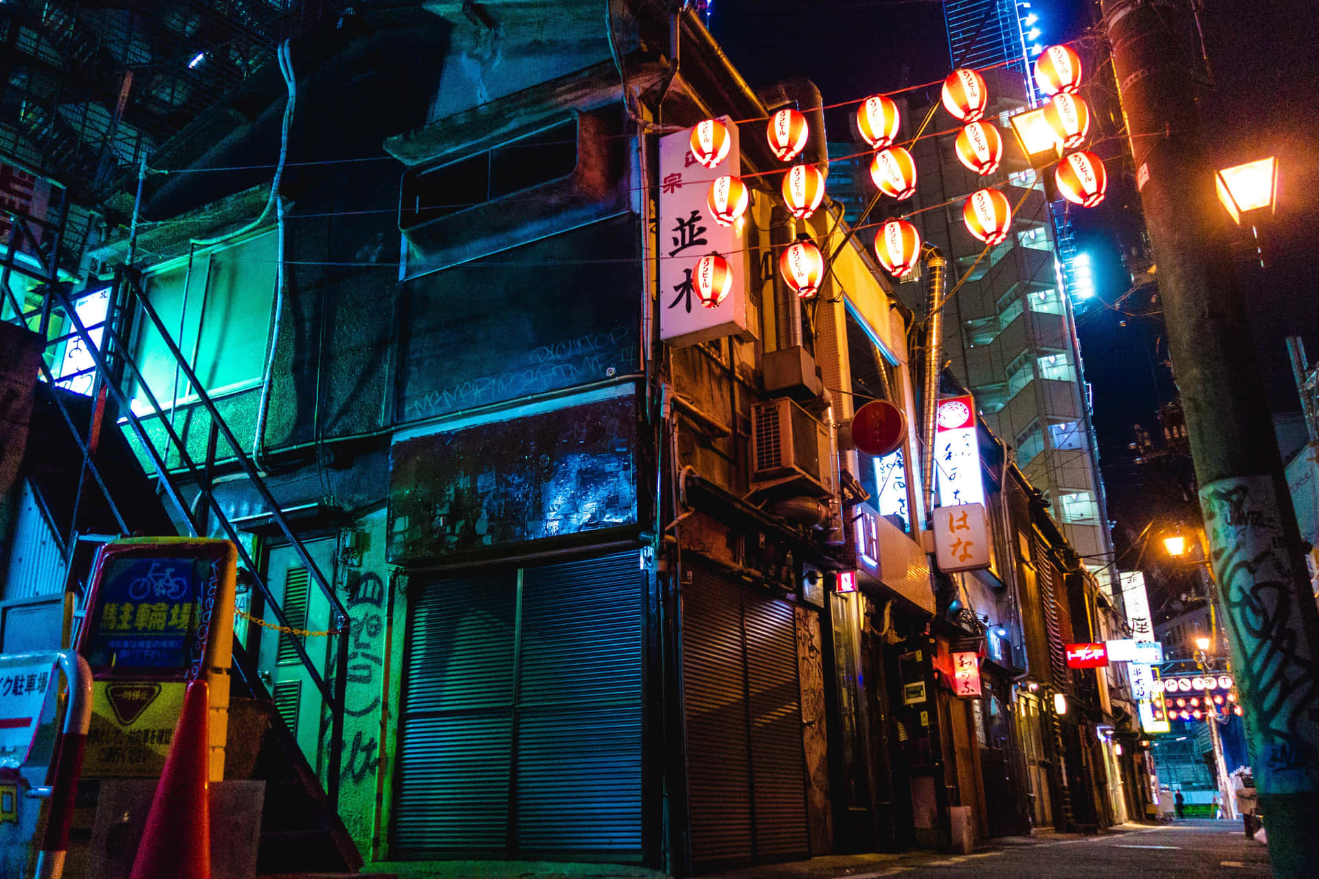 東京夜晚的霓虹燈小巷，掛著紅色燈籠和關閉的商店。