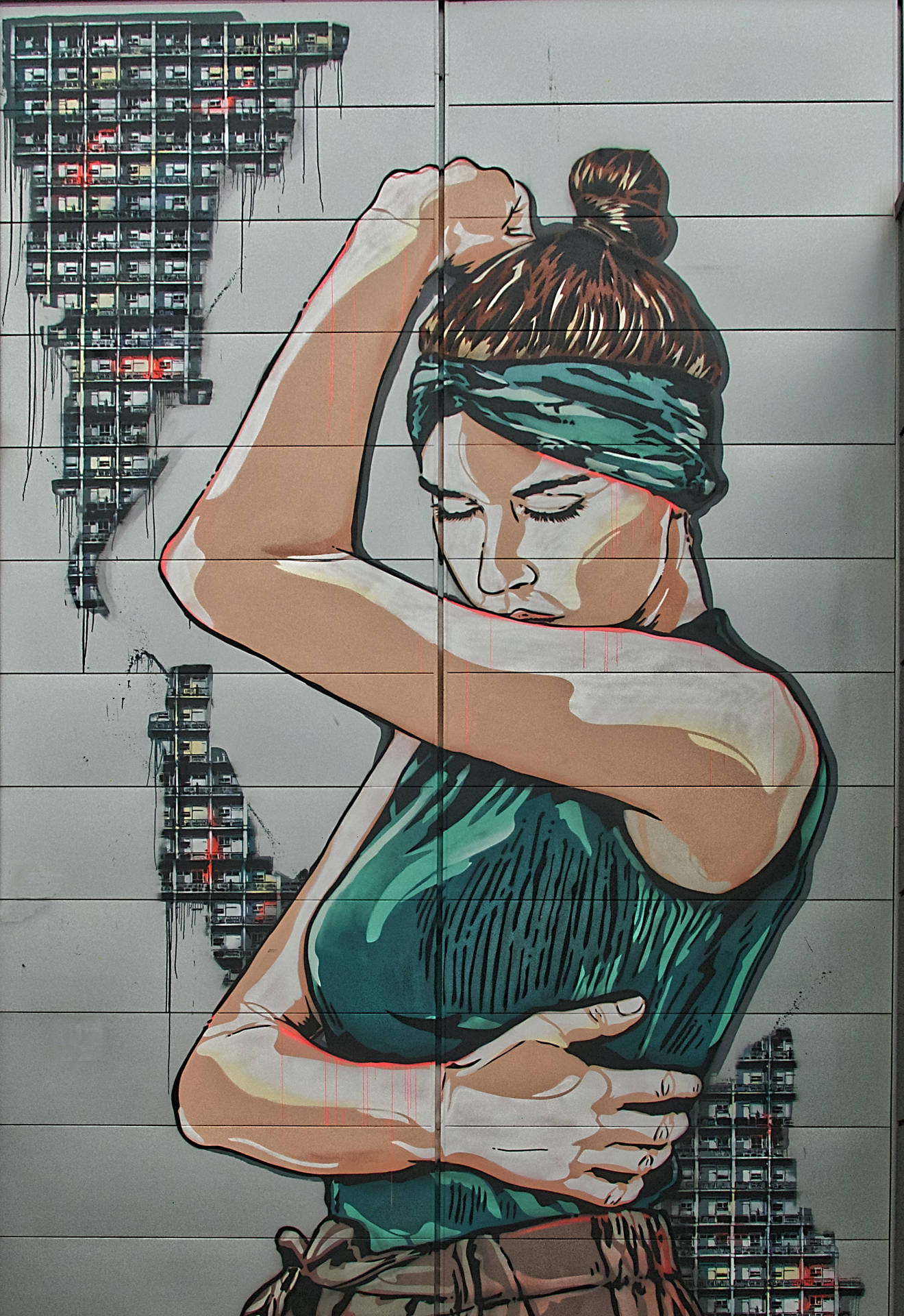一位女性在城市牆上的風格化壁畫中伸展身體。