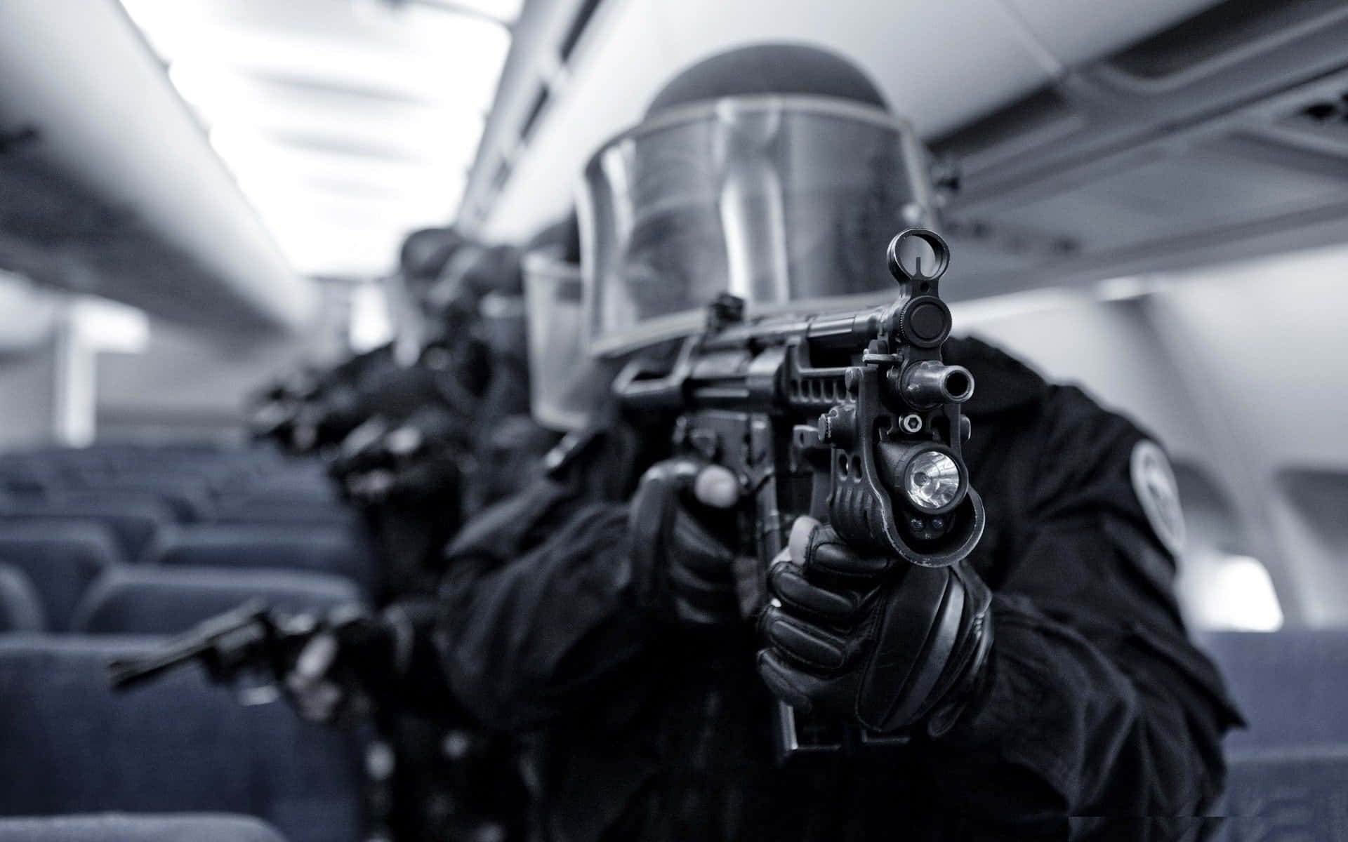 戰術警察穿著防暴裝備，在飛機機艙內手持步槍。