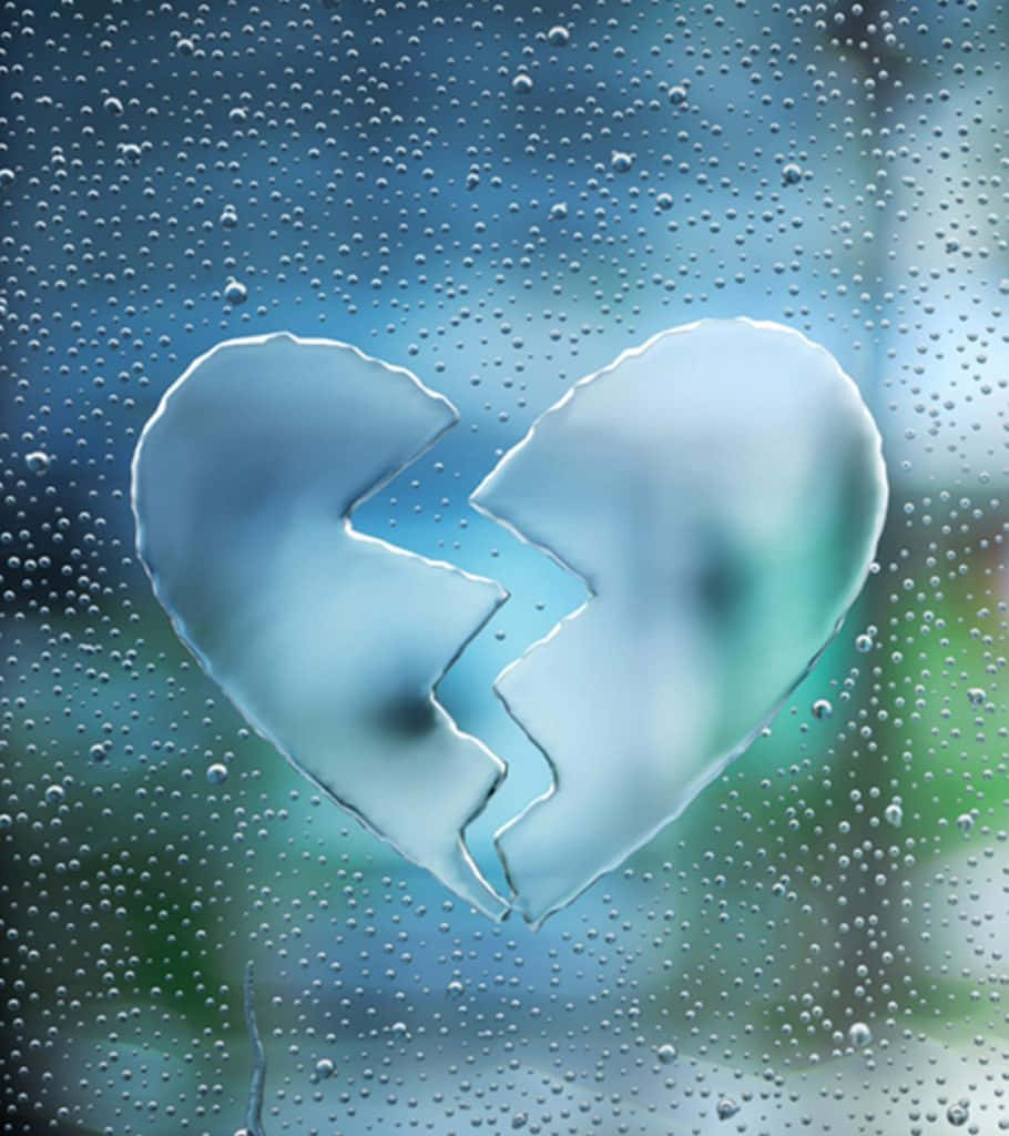 窗戶上的破碎心形 壁紙 — 雨點斑駁的窗戶上出現破碎心形剪影，背景是模糊的藍色和綠色。